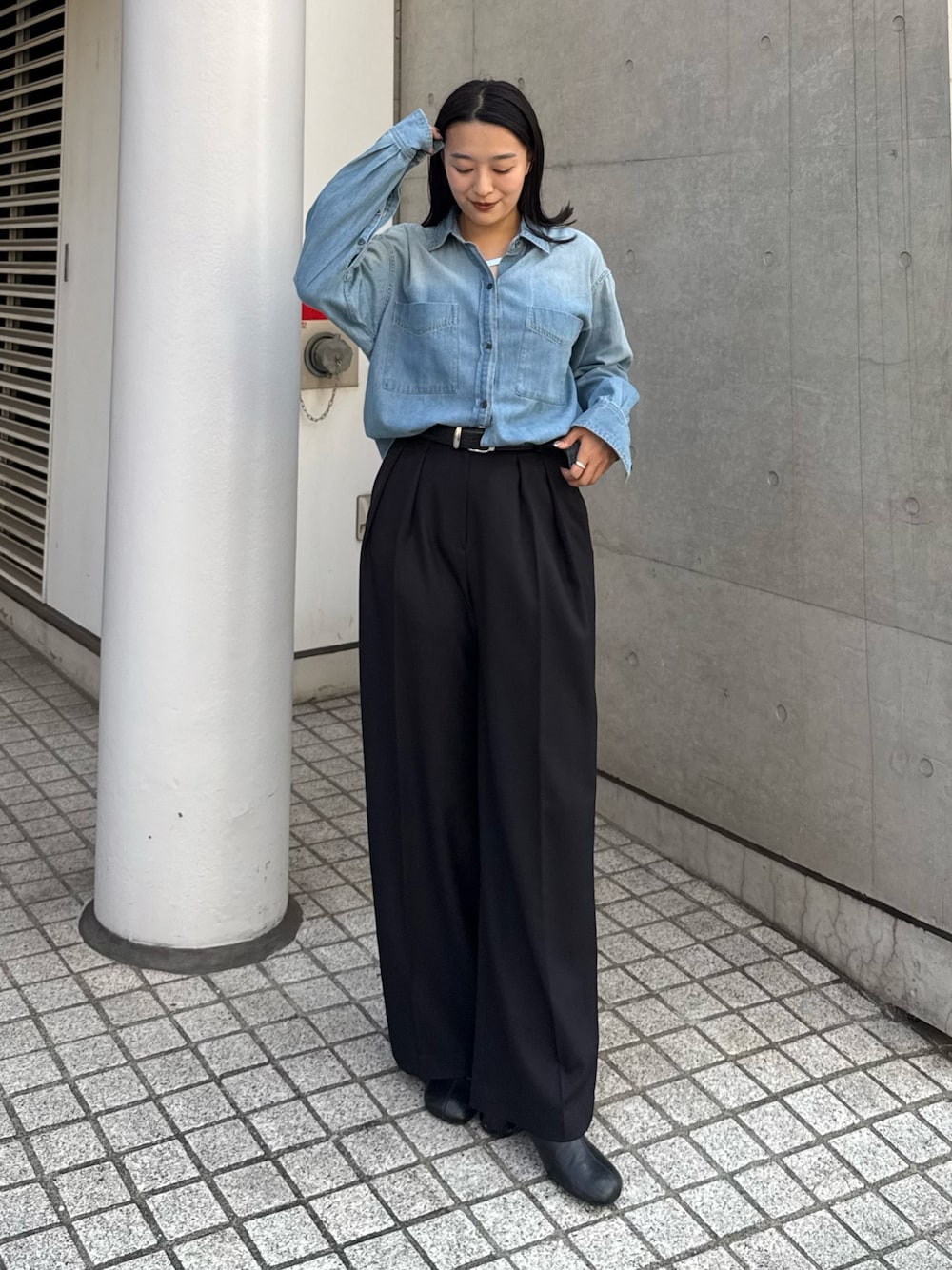 ブルー系のシャツ/ブラウス、ブラック系のスラックス、ブラック系のブーツを着用したレディースの秋コーディネートの1枚目の写真