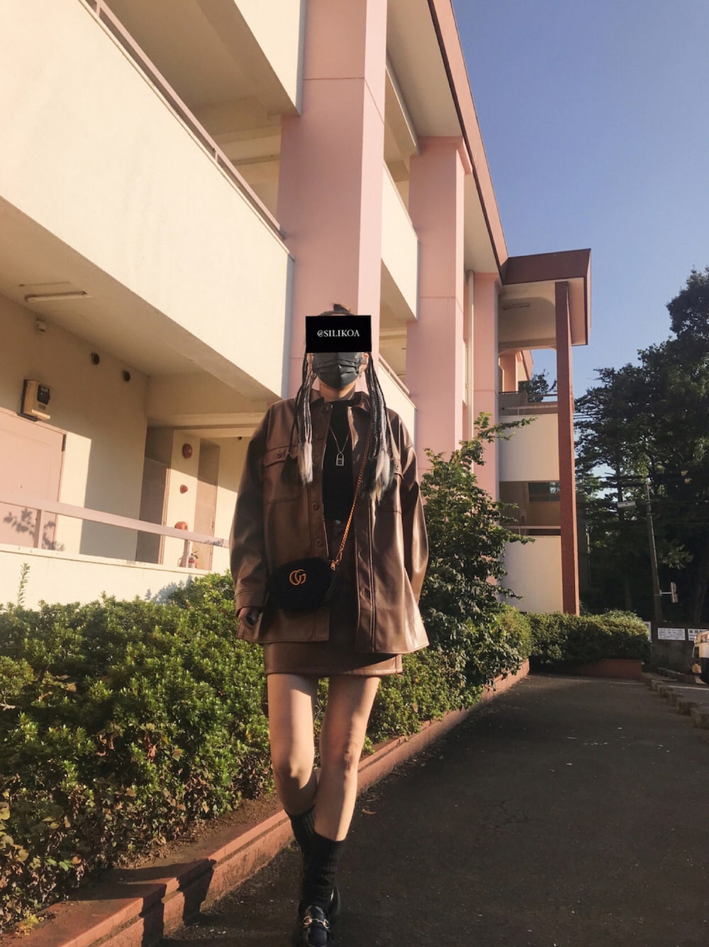 ブラウン系のミリタリージャケット、ブラウン系のスカート、ブラック系のボディバッグ/ウエストポーチを着用したレディースの秋コーディネートの1枚目の写真