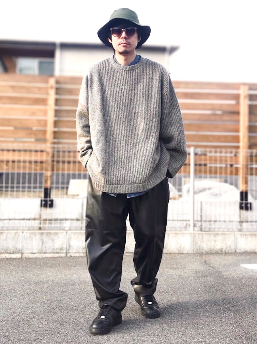 ブラック系のその他パンツ、ブラック系のスニーカー、グレー系のニット/セーターを着用したメンズの冬コーディネートの1枚目の写真