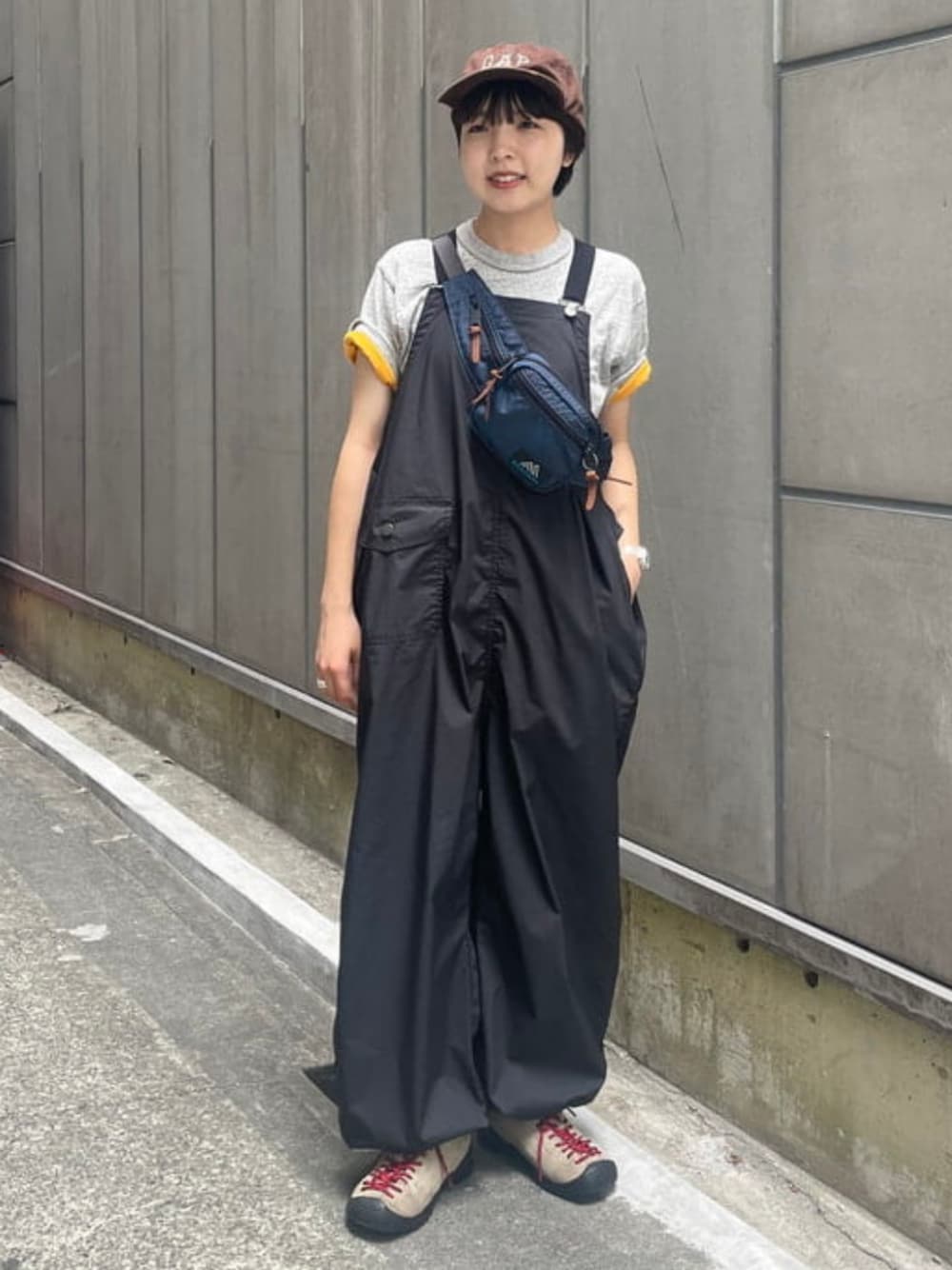 グレー系のTシャツ/カットソー、ブラック系のサロペット/オーバーオール、ブルー系のボディバッグ/ウエストポーチを着用したレディースの夏コーディネートの1枚目の写真