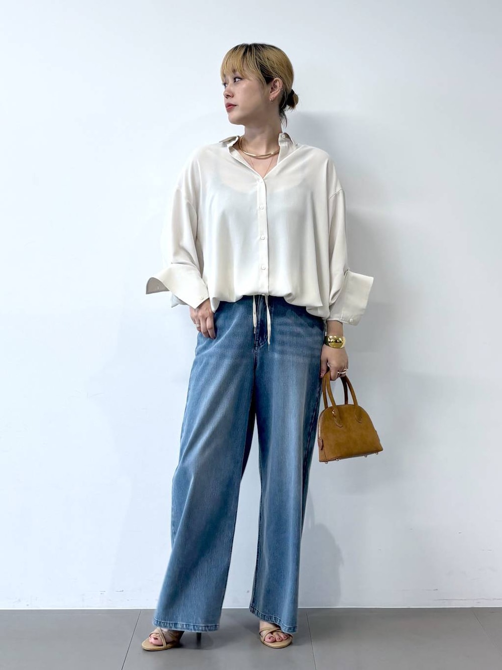 ブルー系のデニムパンツ、ベージュ系のサンダル、ホワイト系のシャツ/ブラウスを着用したレディースの夏コーディネートの1枚目の写真