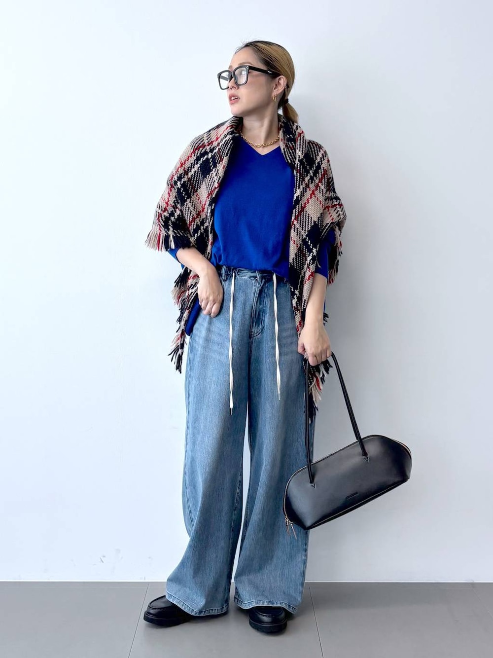 ブラック系のトートバッグ、ブルー系のデニムパンツ、ブラック系のローファーを着用したレディースの秋コーディネートの1枚目の写真