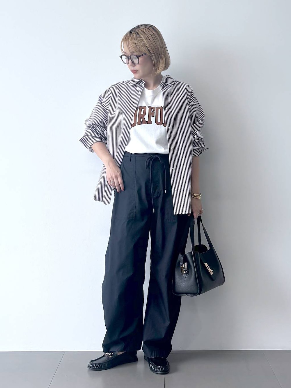 ブラック系のローファー、ブルー系のカーゴパンツ、ホワイト系のTシャツ/カットソーを着用したレディースの秋コーディネートの1枚目の写真