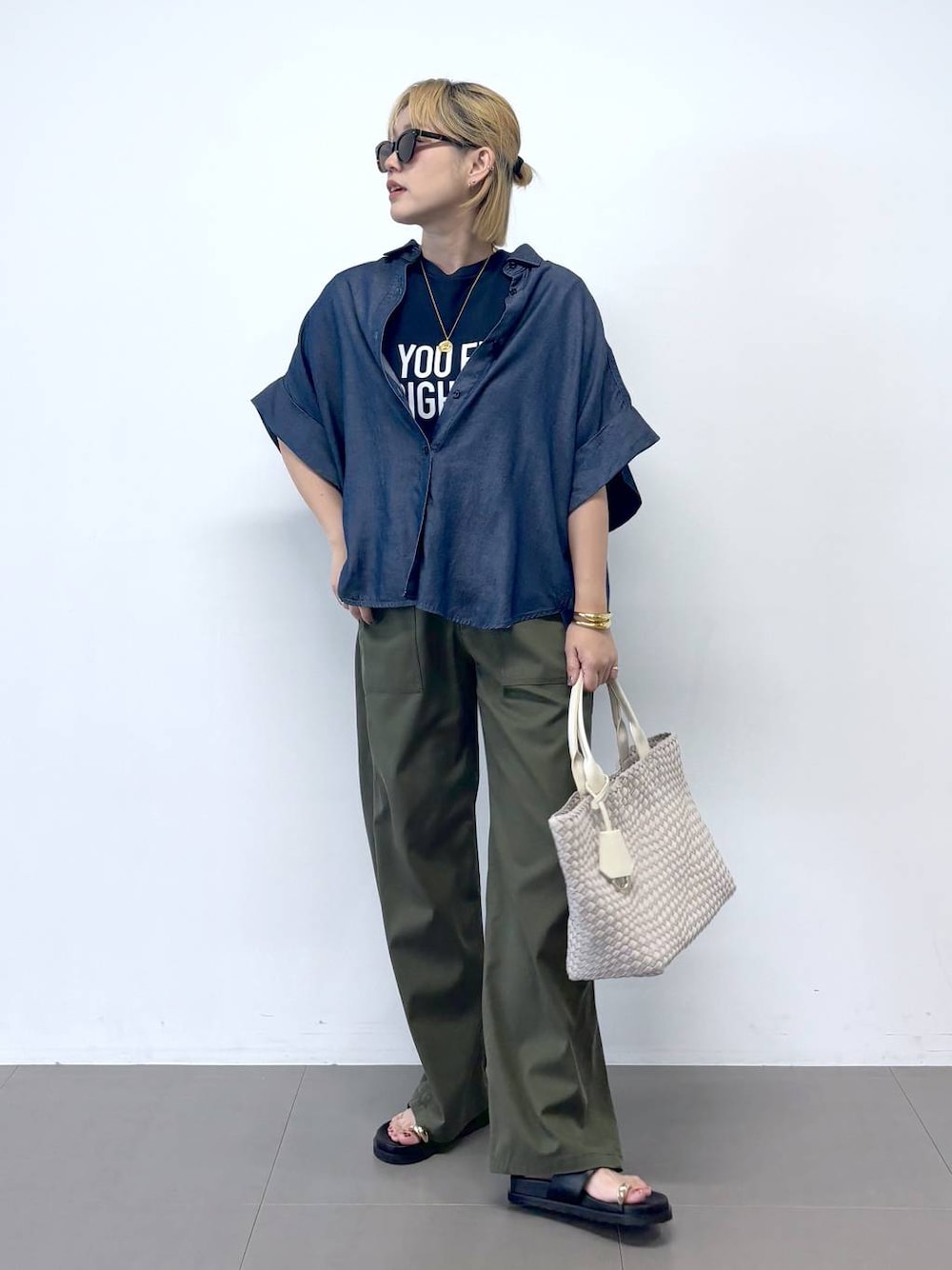 グリーン系のチノパンツ、ブルー系のTシャツ/カットソー、ブラック系のサンダルを着用したレディースの夏コーディネートの1枚目の写真
