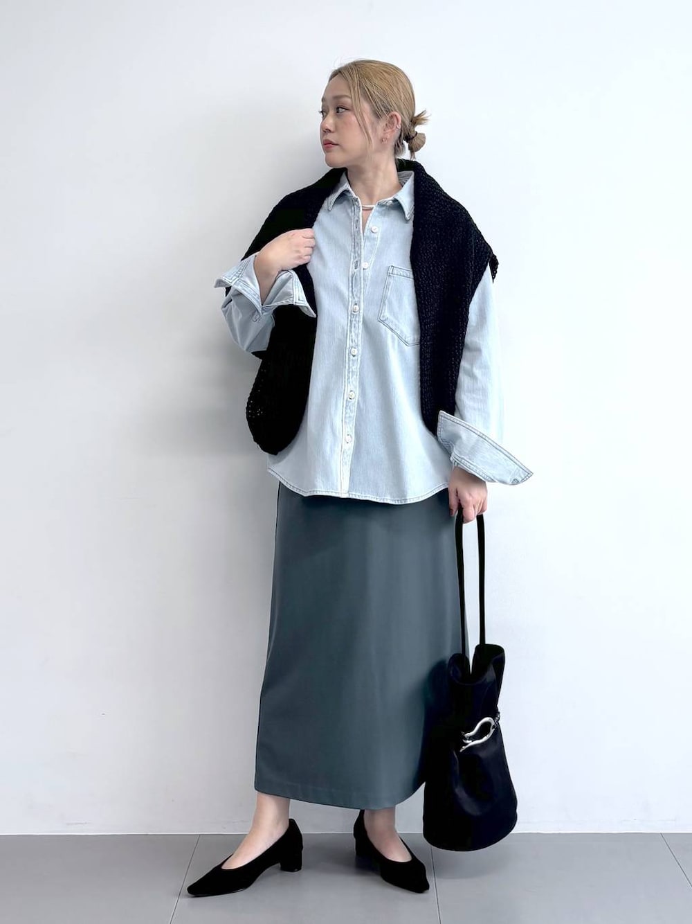 ブルー系のシャツ/ブラウス、ブラック系のニット/セーター、ブラック系のパンプスを着用したレディースの冬コーディネートの1枚目の写真