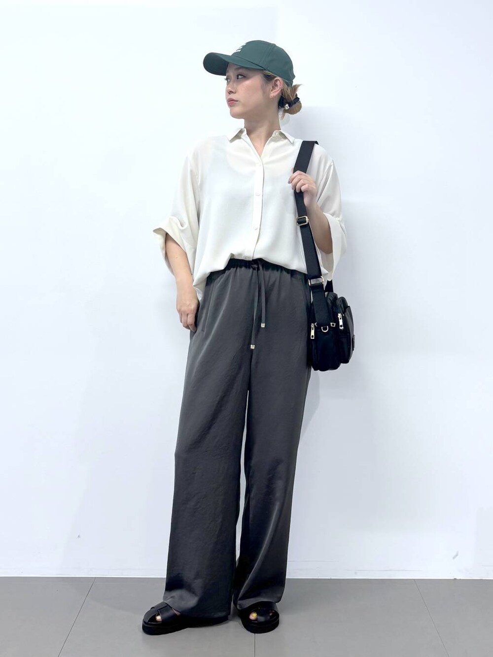 グレー系のその他パンツ、ホワイト系のシャツ/ブラウス、ブラック系のサンダルを着用したレディースの春コーディネートの1枚目の写真