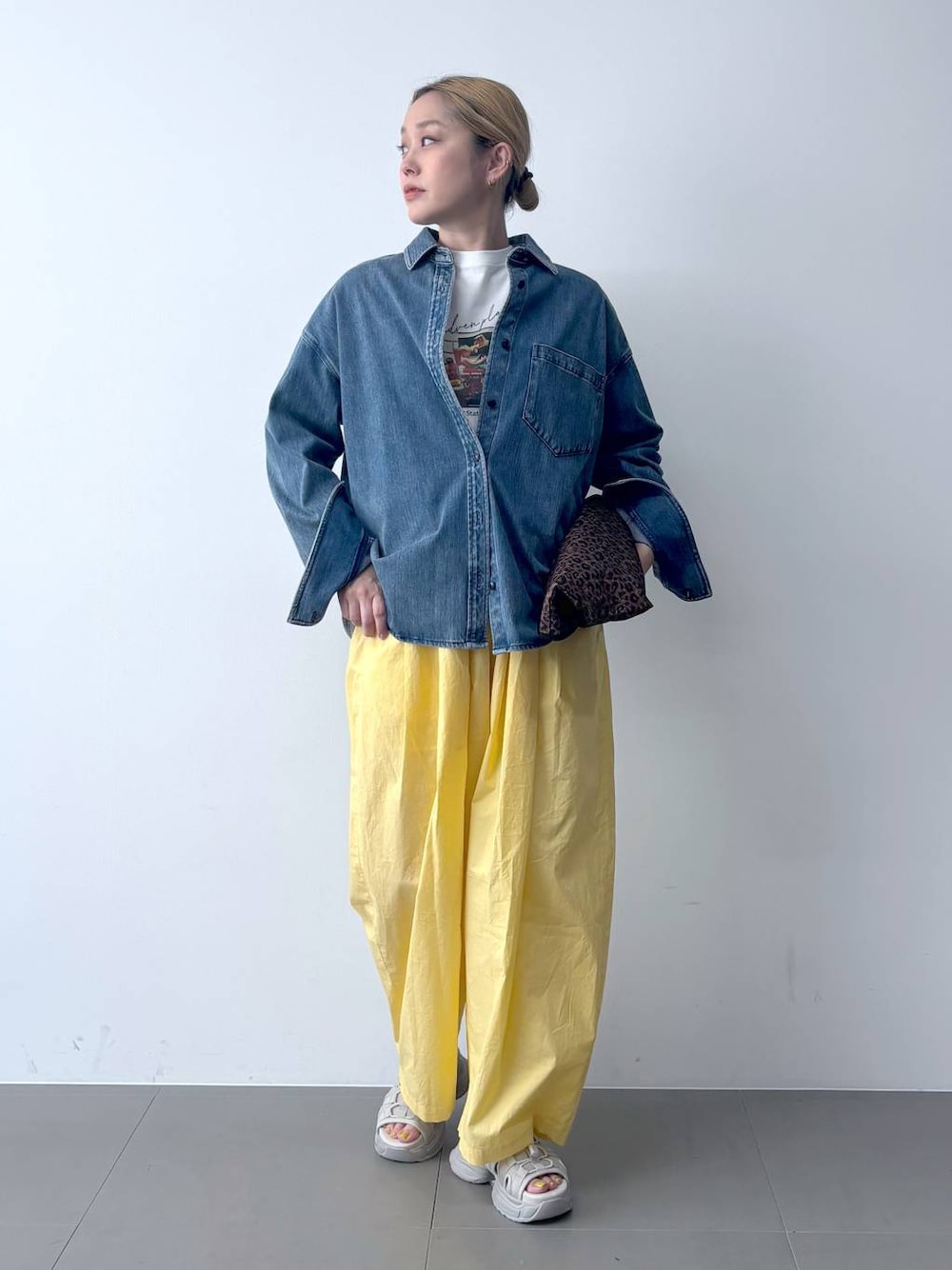 イエロー系のその他パンツ、ブルー系のシャツ/ブラウス、その他のトートバッグを着用したレディースの春コーディネートの1枚目の写真