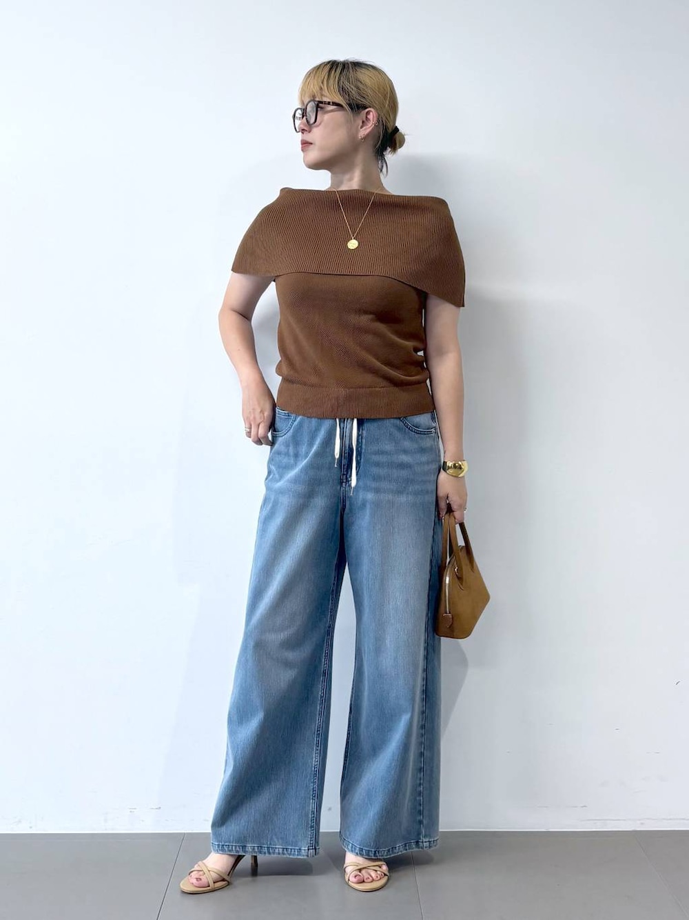 ブルー系のデニムパンツ、ベージュ系のサンダル、ブラウン系のニット/セーターを着用したレディースの夏コーディネートの1枚目の写真