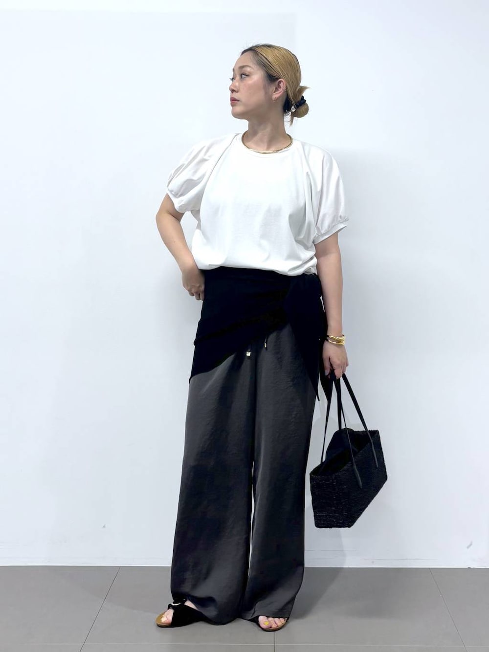 グレー系のその他パンツ、ホワイト系のTシャツ/カットソー、ブラック系のサンダルを着用したレディースの春コーディネートの1枚目の写真