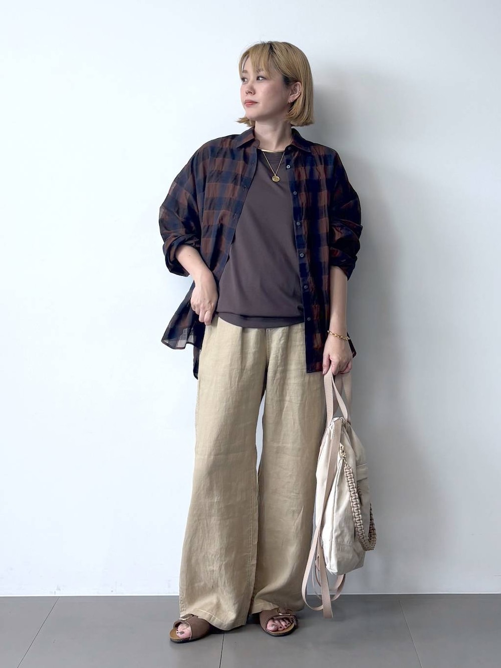 ベージュ系のその他パンツ、ブラウン系のサンダル、ブラウン系のTシャツ/カットソーを着用したレディースの夏コーディネートの1枚目の写真