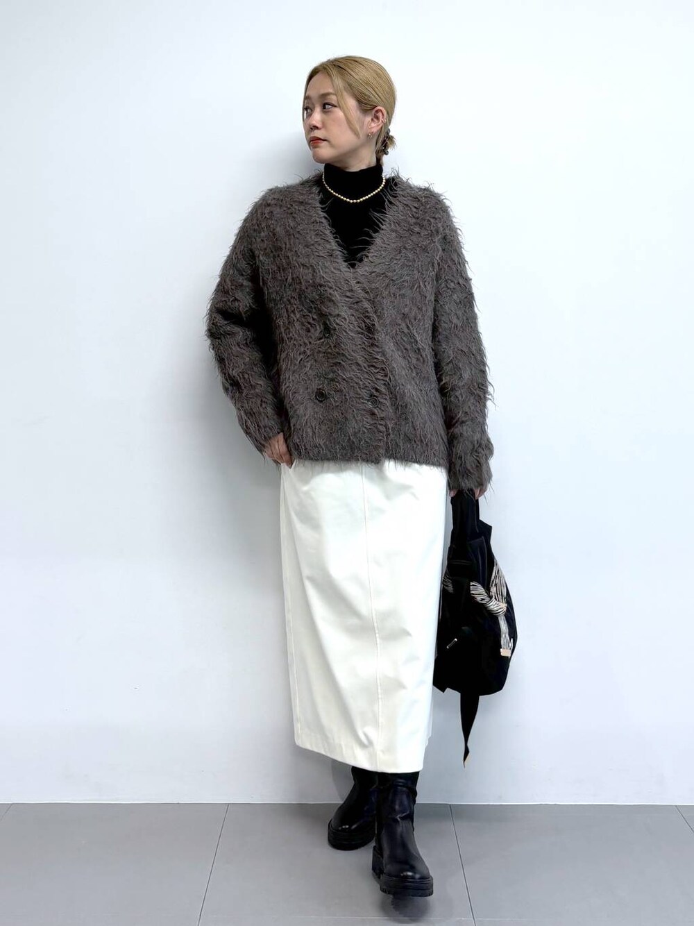 ブラック系のブーツ、ブラウン系のカーディガン/ボレロ、その他のショルダーバッグを着用したレディースの秋コーディネートの1枚目の写真