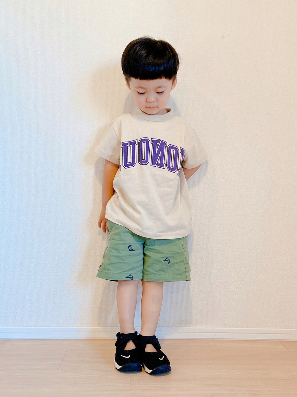 ベージュ系のTシャツ/カットソー、グリーン系のカーゴパンツ、ブラック系のスニーカーを着用したキッズの秋コーディネートの1枚目の写真