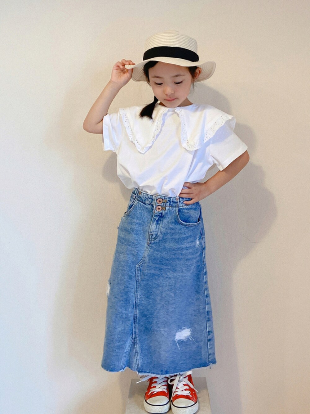 ホワイト系のTシャツ/カットソー、ブルー系のデニムスカート、レッド系のスニーカーを着用したキッズの夏コーディネートの1枚目の写真