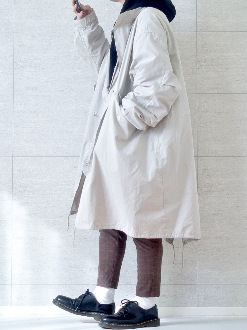 ホワイト系のその他アウター、ブラウン系のスラックス、ブラック系のブーツを着用したメンズの冬コーディネートの1枚目の写真