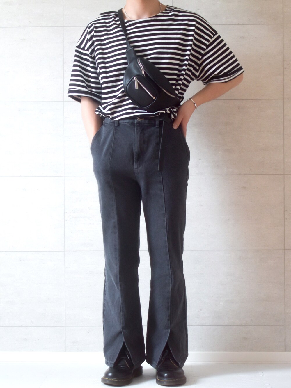 グレー系のデニムパンツ、ブラック系のブーツ、ブラック系のボディバッグ/ウエストポーチを着用したメンズの春コーディネートの1枚目の写真