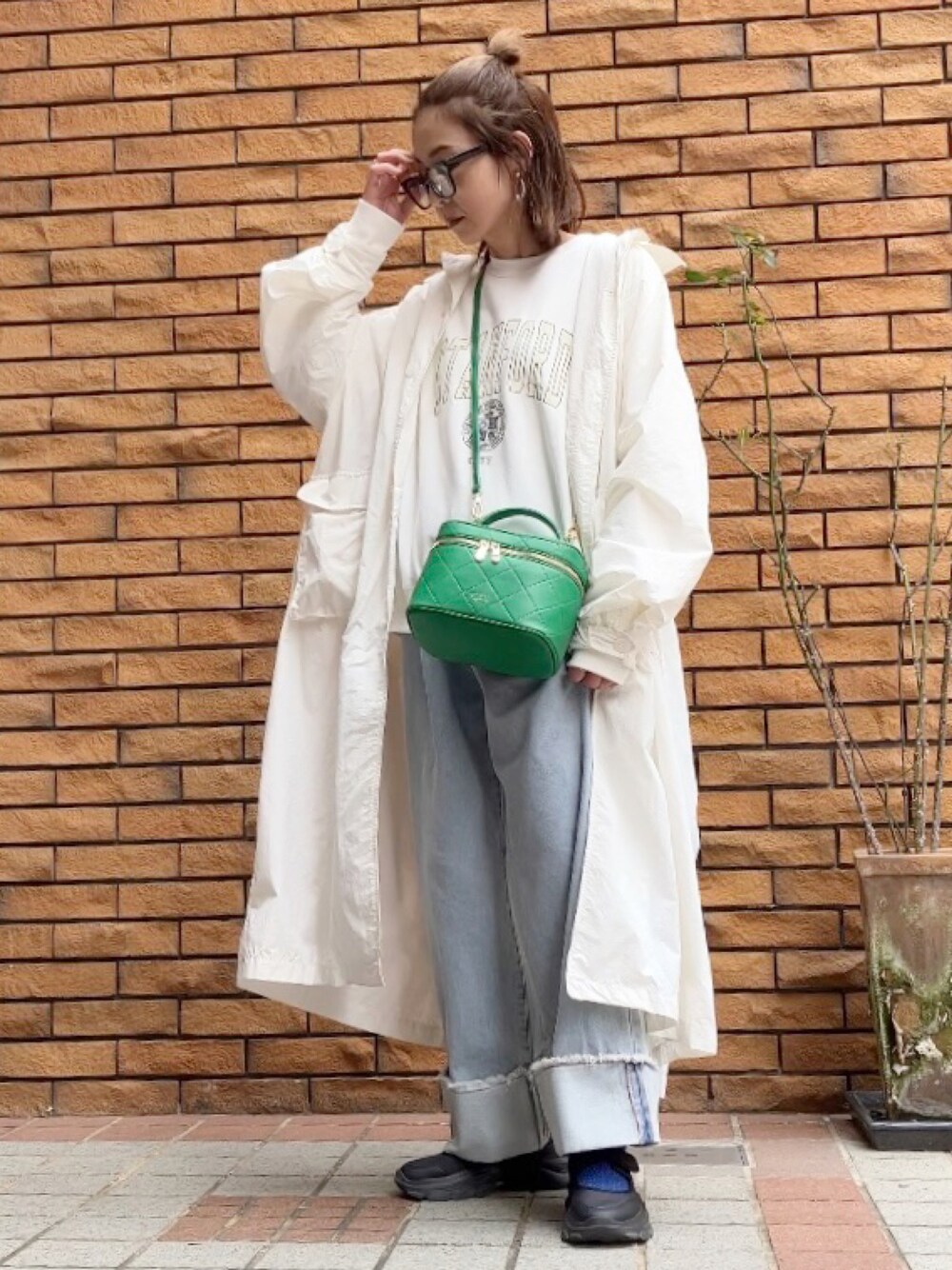 ホワイト系のスウェット、ブルー系のデニムパンツ、グリーン系のショルダーバッグを着用したレディースの春コーディネートの1枚目の写真