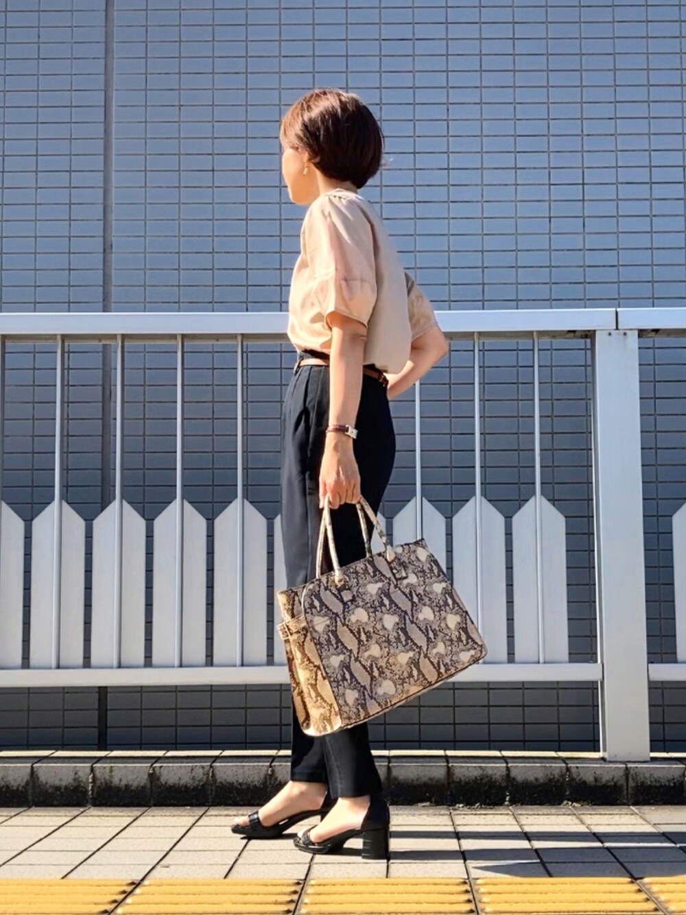 ベージュ系のシャツ/ブラウス、ブラック系のパンツ、ベージュ系のバッグを着用したレディースの夏コーディネートの1枚目の写真