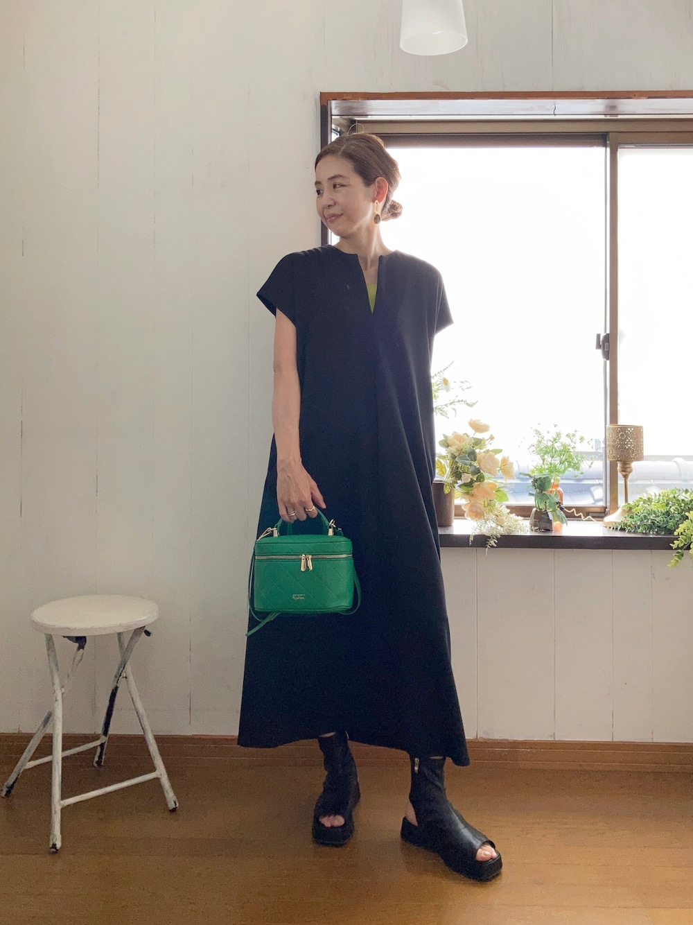 ブラック系のワンピース、グリーン系のタンクトップ、グリーン系のショルダーバッグを着用したレディースの夏コーディネートの1枚目の写真