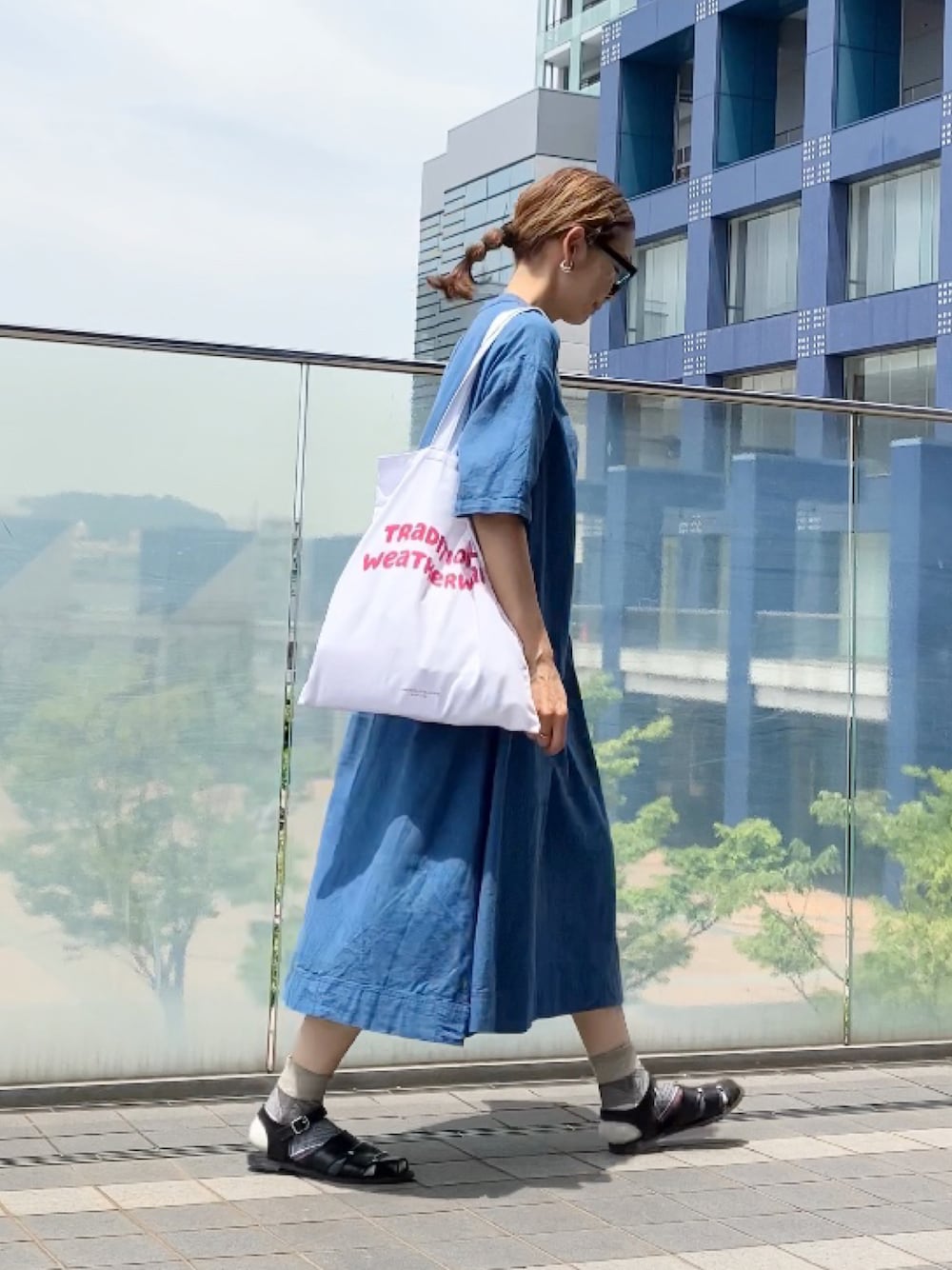 ブルー系のワンピース/ドレス、ブラック系のサンダル、レッド系のトートバッグを着用したレディースの夏コーディネートの1枚目の写真