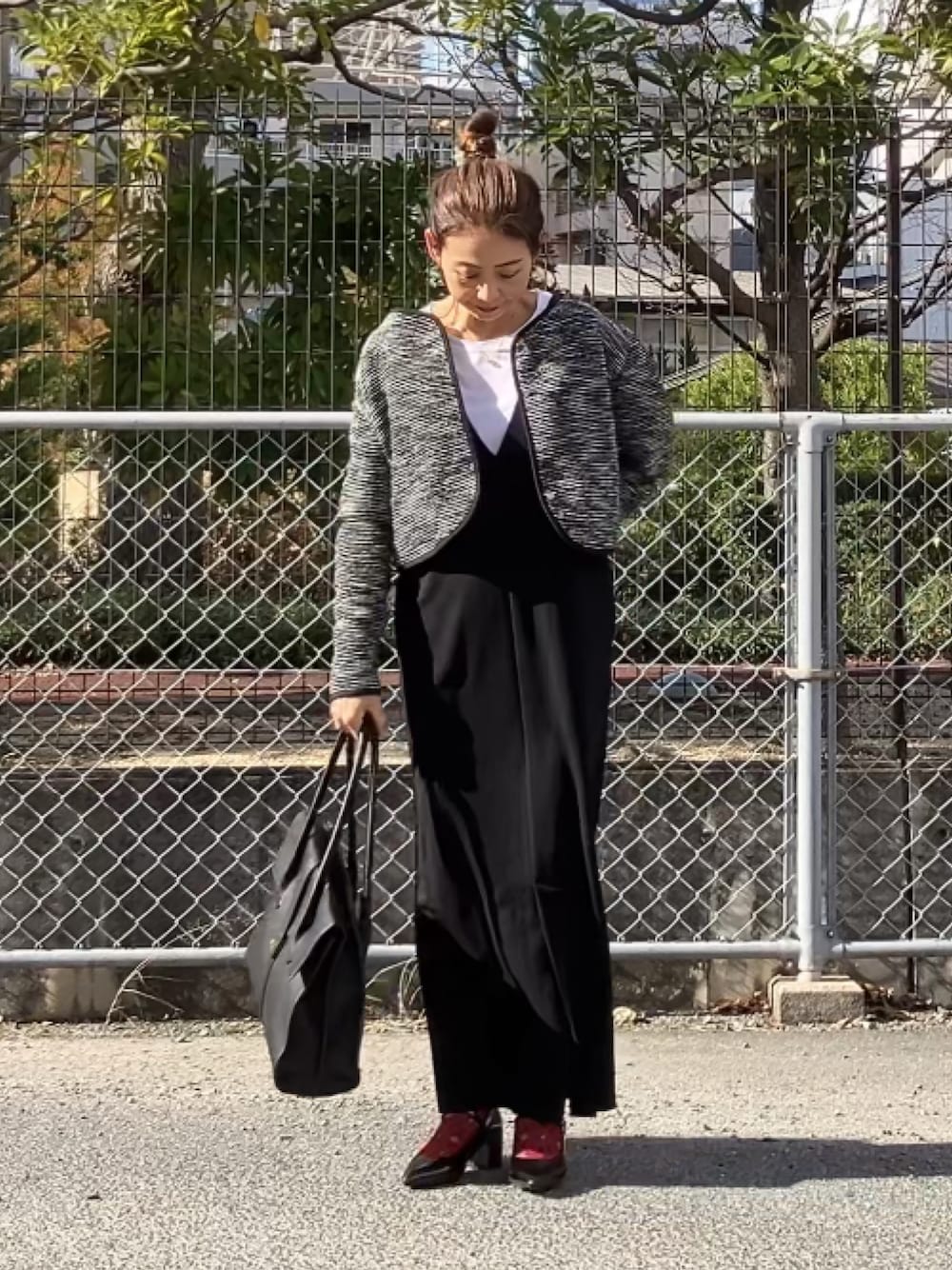 ブラック系のノーカラージャケット、ブラック系のジャンパースカート、ホワイト系のTシャツ/カットソーを着用したレディースの冬コーディネートの1枚目の写真