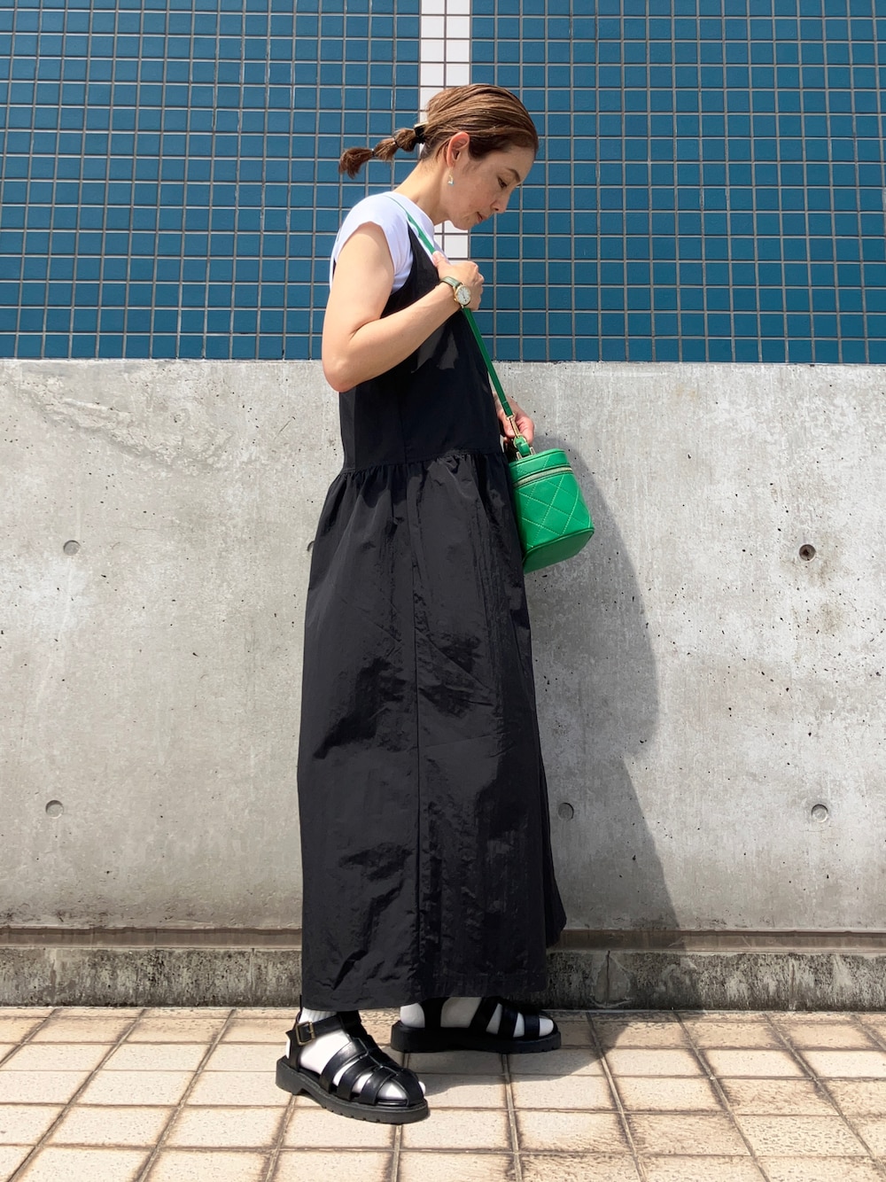 ホワイト系のTシャツ/カットソー、ブラック系のワンピース/ドレス、グリーン系のショルダーバッグを着用したレディースの春コーディネートの1枚目の写真