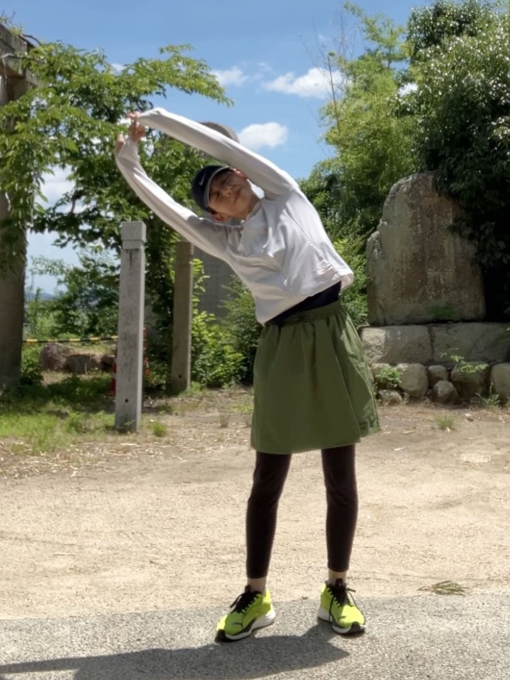 グリーン系のスカート、グリーン系のスニーカーを着用したレディースの夏コーディネートの1枚目の写真