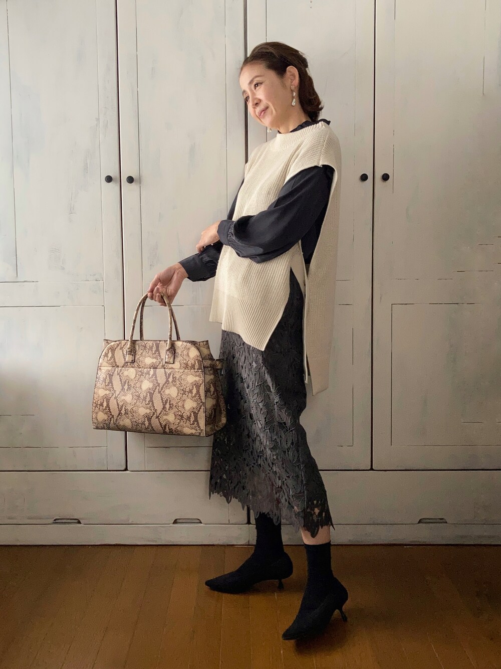 ホワイト系のベスト、ブラック系のシャツ/ブラウス、その他のスカートを着用したレディースの春コーディネートの1枚目の写真