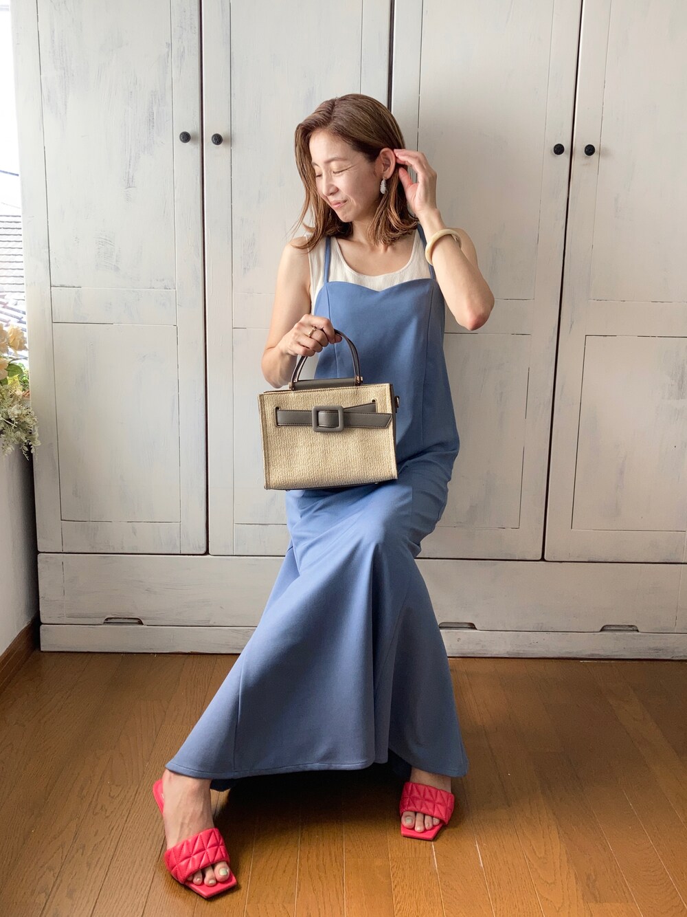 ブルー系のワンピース、グレー系のハンドバッグ、ピンク系のサンダルを着用したレディースの夏コーディネートの1枚目の写真
