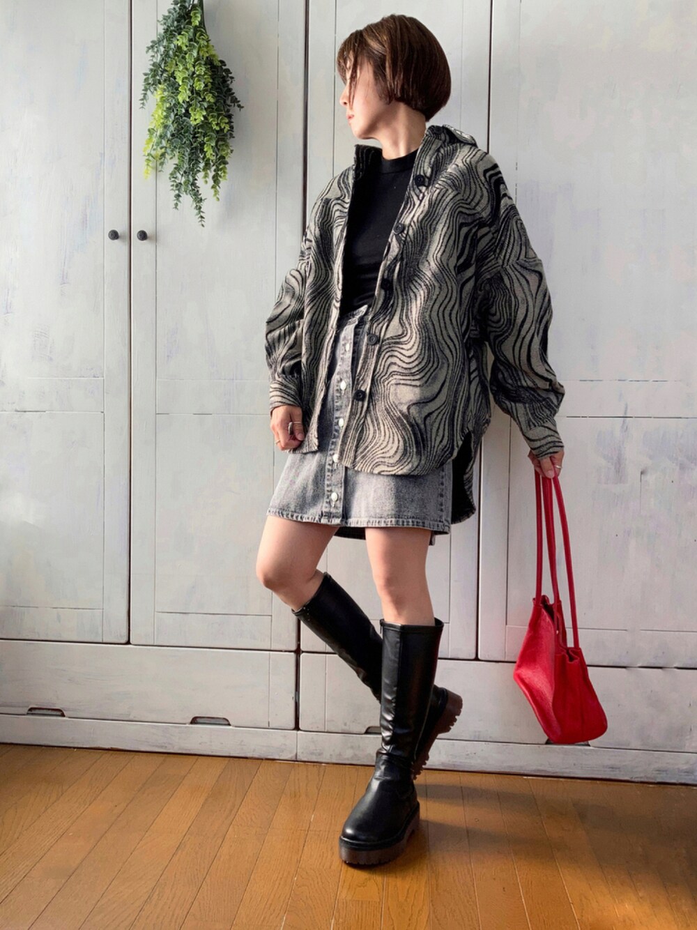 その他のブルゾン、ブラック系のデニムスカート、ブラック系のブーツを着用したレディースの秋コーディネートの1枚目の写真