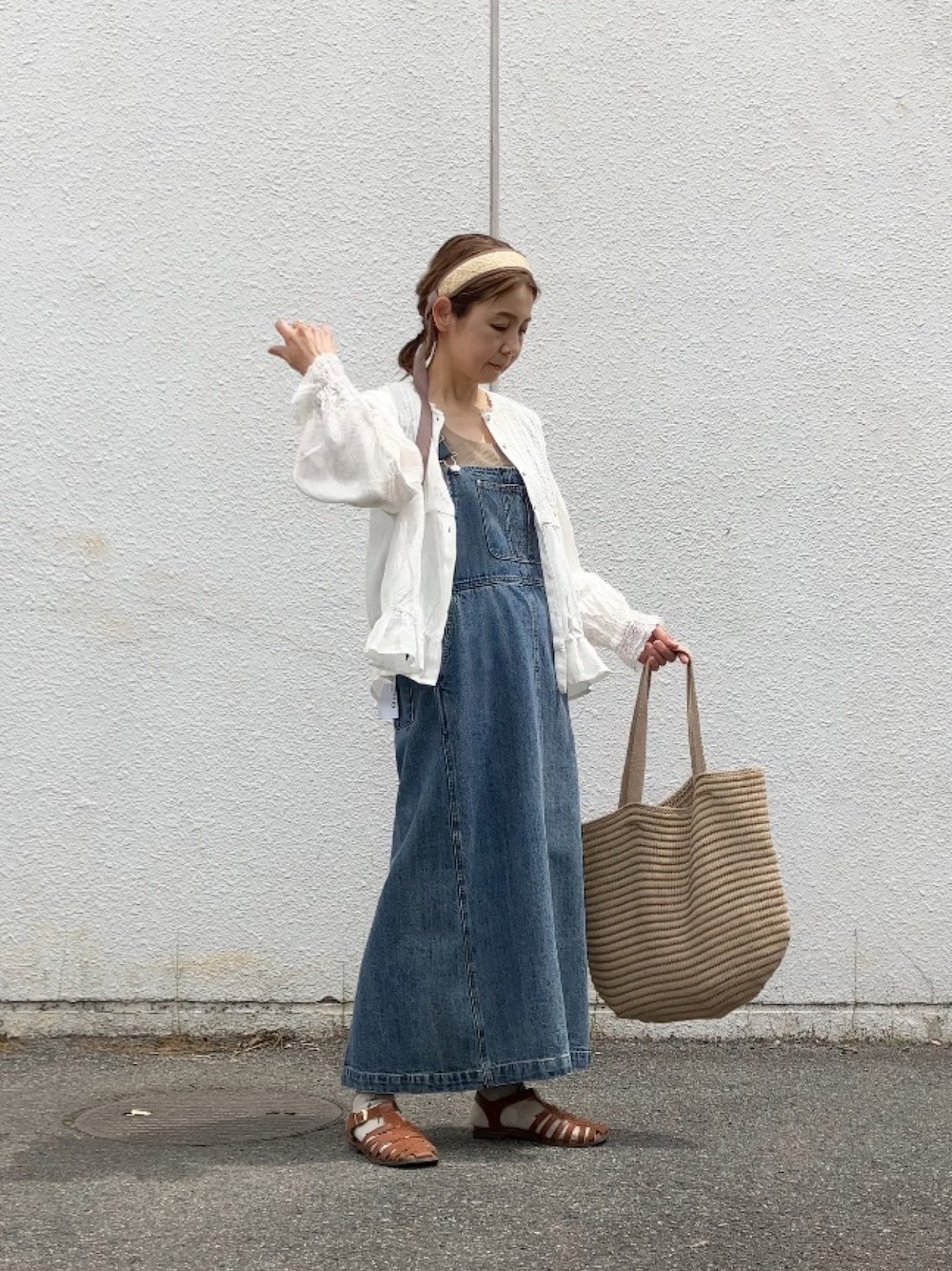 ブルー系のサロペット/オーバーオール、ホワイト系のシャツ/ブラウス、ブラウン系のサンダルを着用したレディースの春コーディネートの1枚目の写真