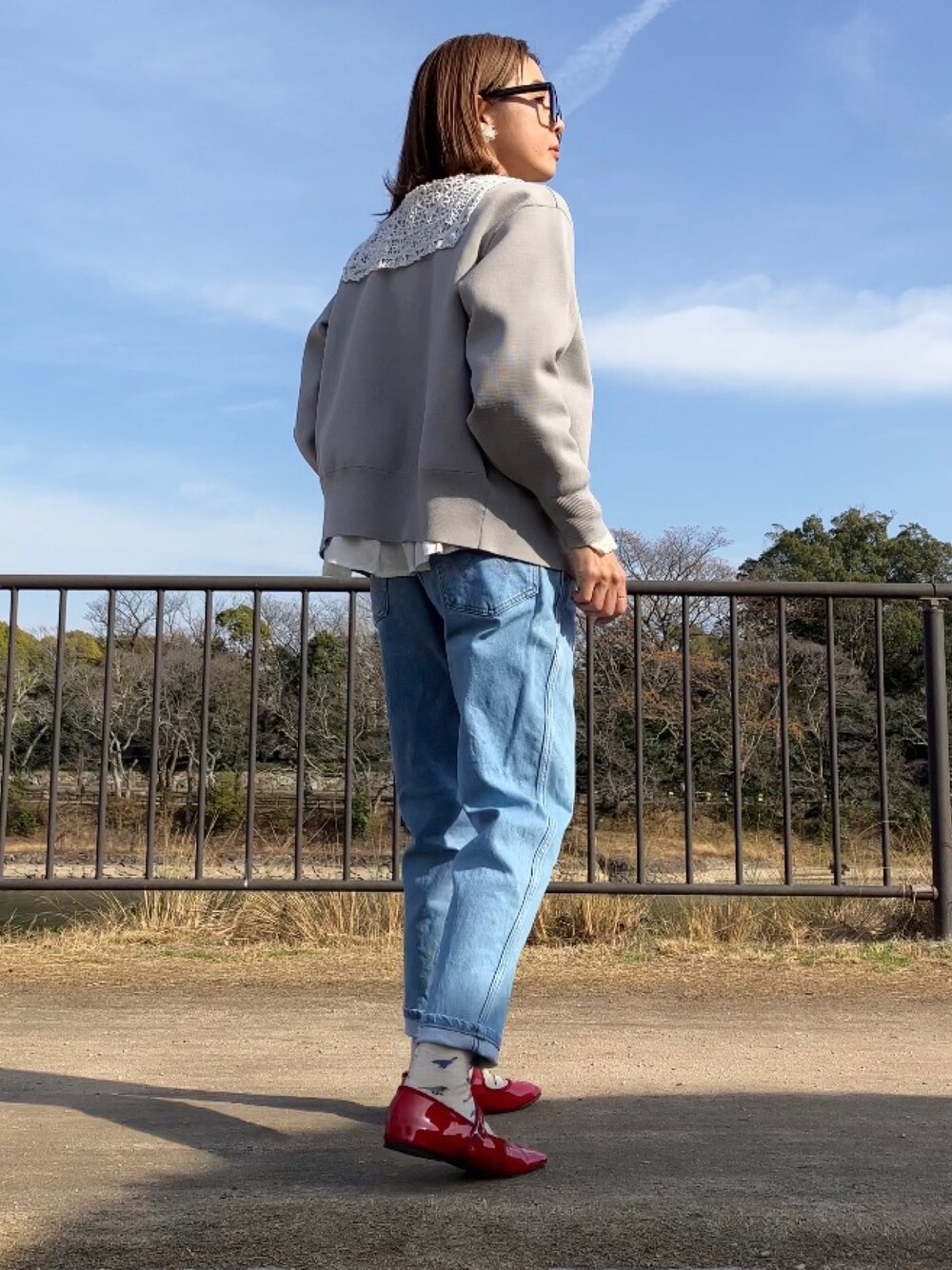 レッド系のパンプス、ホワイト系のシャツ/ブラウス、グレー系のカーディガン/ボレロを着用したレディースの冬コーディネートの1枚目の写真