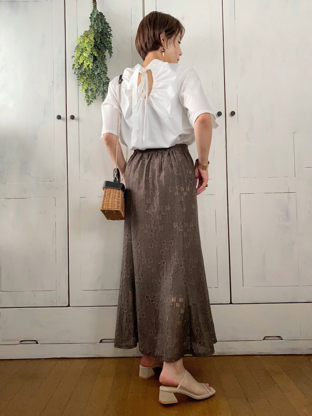 ホワイト系のシャツ/ブラウス、グリーン系のスカート、ベージュ系のサンダルを着用したレディースの夏コーディネートの1枚目の写真