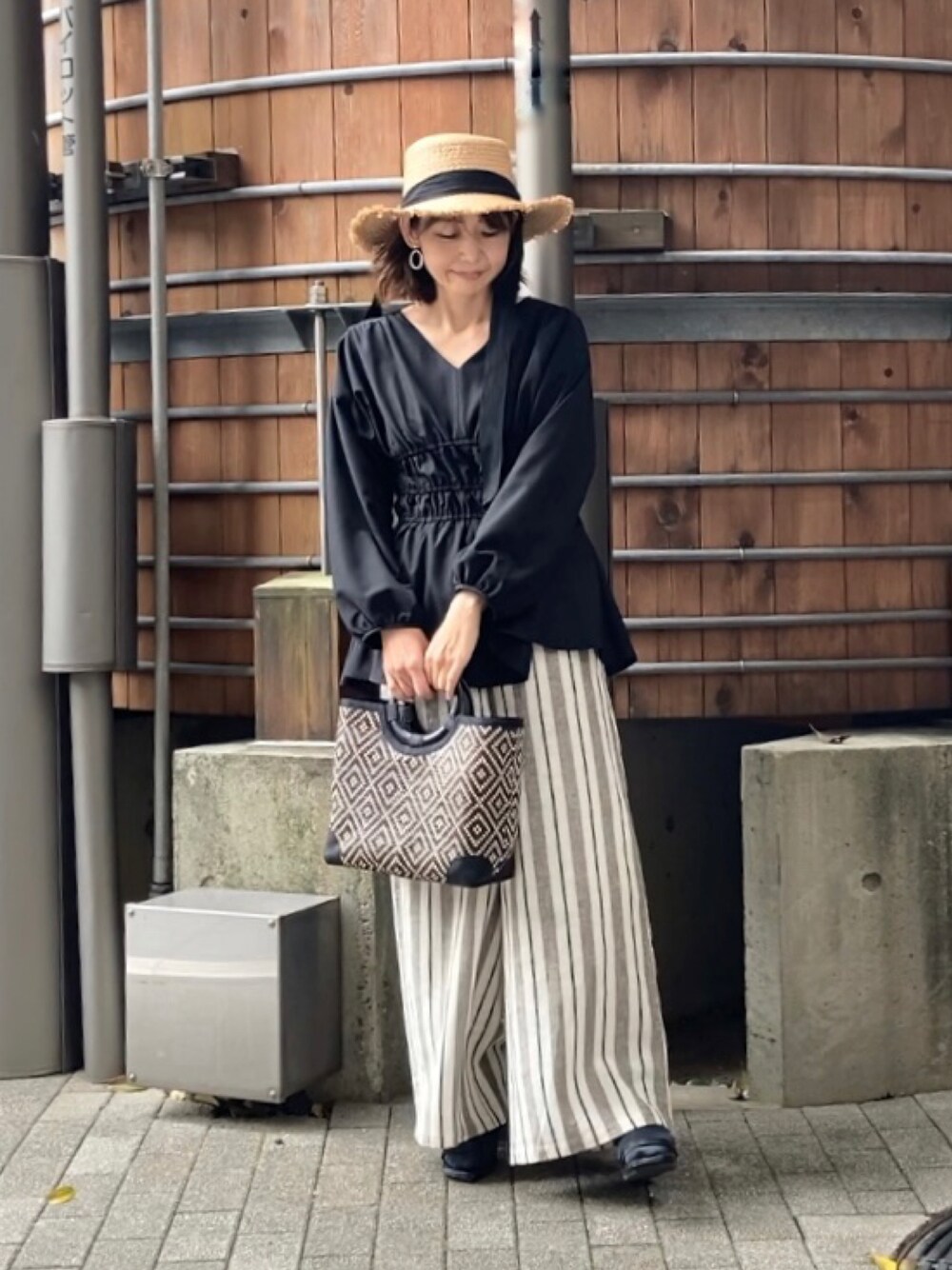 ブラック系のシャツ/ブラウス、その他のその他パンツ、ブラック系のかごバッグを着用したレディースの春コーディネートの1枚目の写真