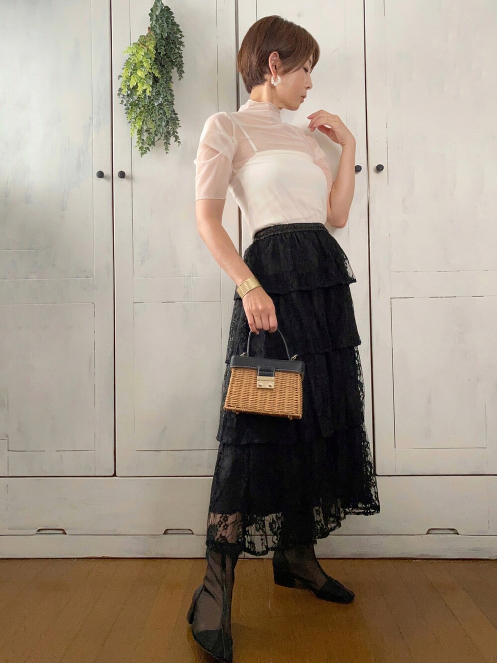 ホワイト系のシャツ/ブラウス、ブラック系のスカート、ブラウン系のかごバッグを着用したレディースの夏コーディネートの1枚目の写真