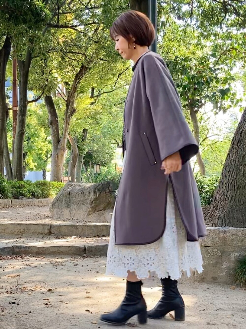 ブラウン系のその他アウター、ブラック系のTシャツ/カットソー、ホワイト系のスカートを着用したレディースの秋コーディネートの1枚目の写真