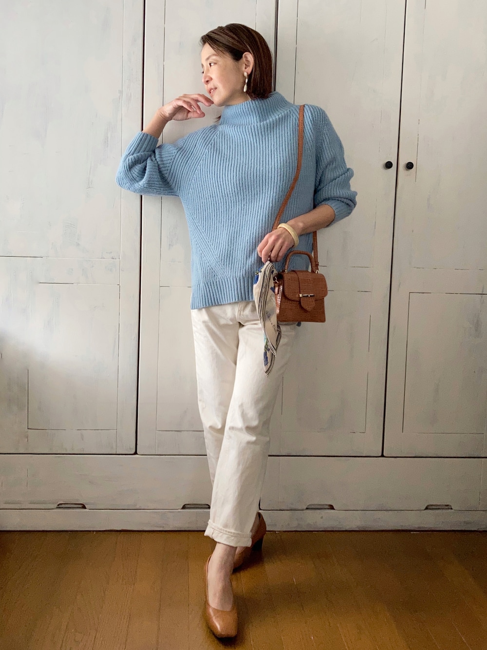 ブルー系のニット/セーター、ホワイト系のデニムパンツ、ベージュ系のパンプスを着用したレディースの冬コーディネートの1枚目の写真