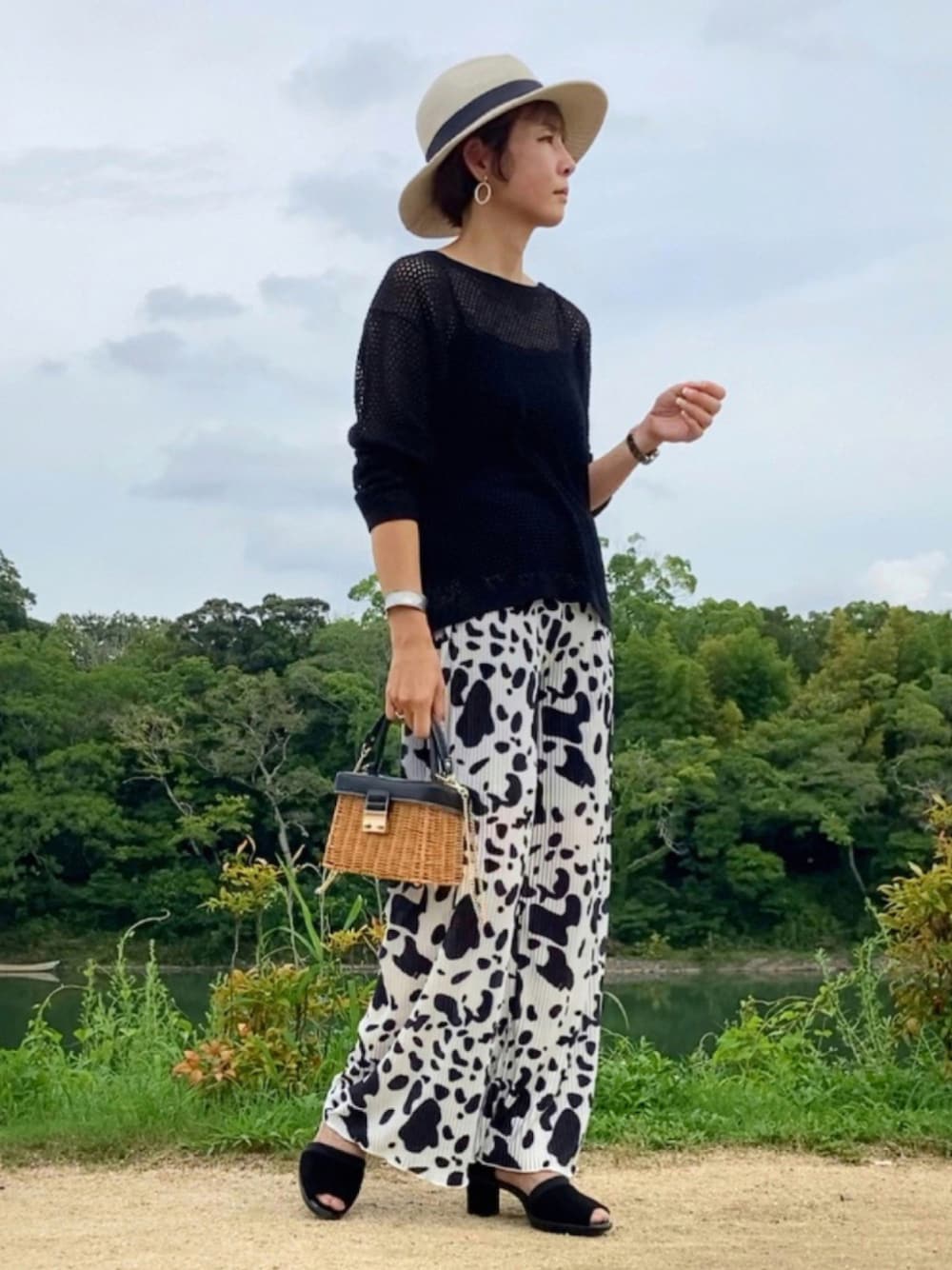 ホワイト系のその他パンツ、ブラック系のニット/セーター、ブラック系のサンダルを着用したレディースの夏コーディネートの1枚目の写真