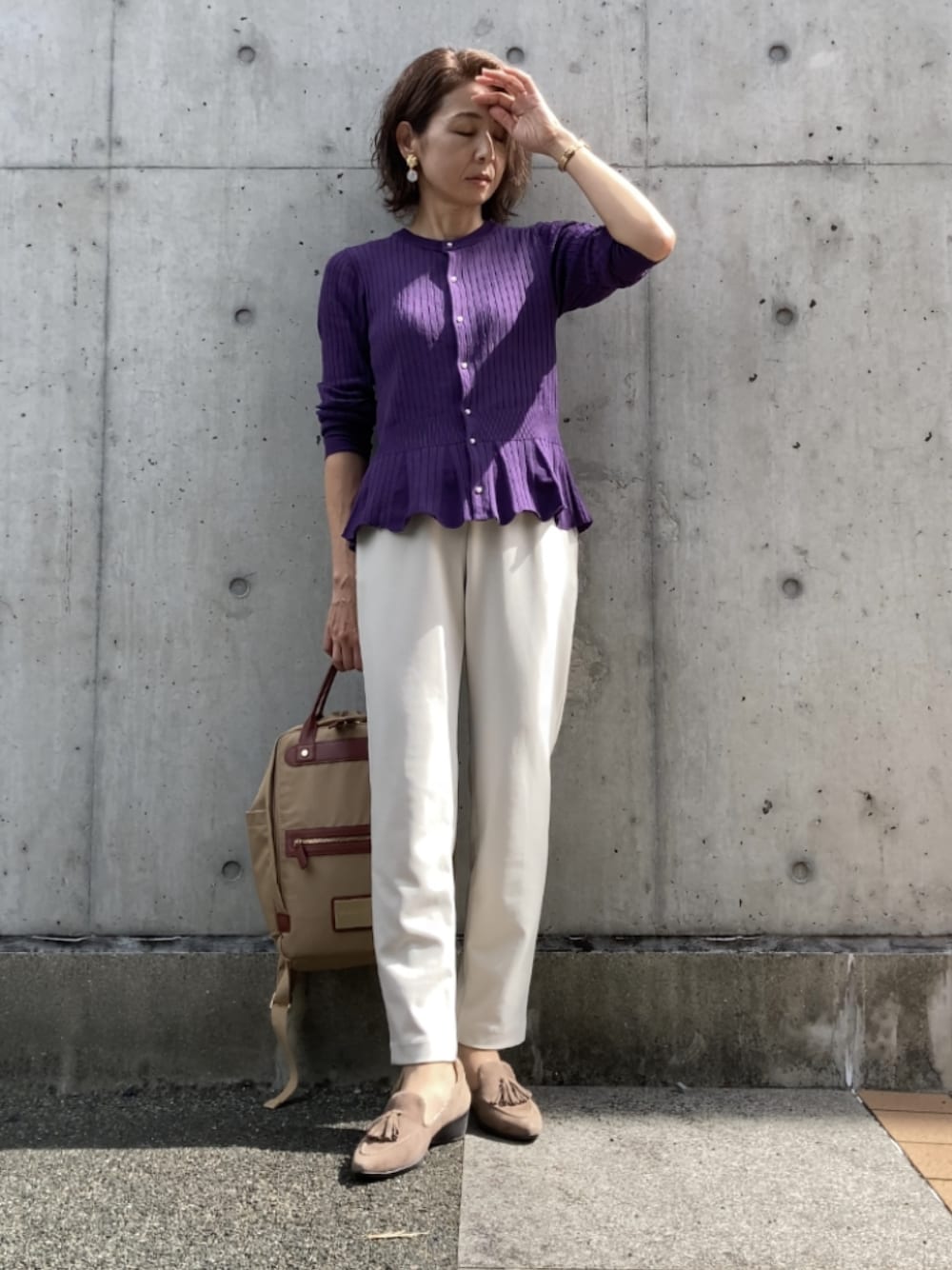 パープル系のカーディガン/ボレロ、ホワイト系のパンツ、ベージュ系のバックパック/リュックを着用したレディースの秋コーディネートの1枚目の写真