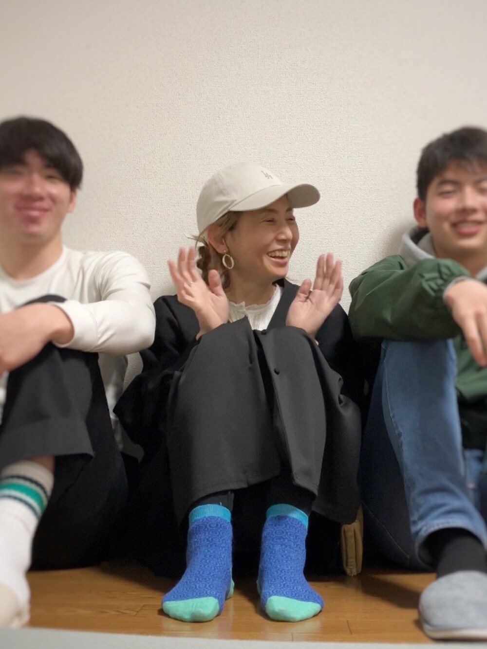 ブラック系のモッズコート、ブラック系のカーディガン/ボレロ、ホワイト系のシャツ/ブラウスを着用したレディースの春コーディネートの1枚目の写真