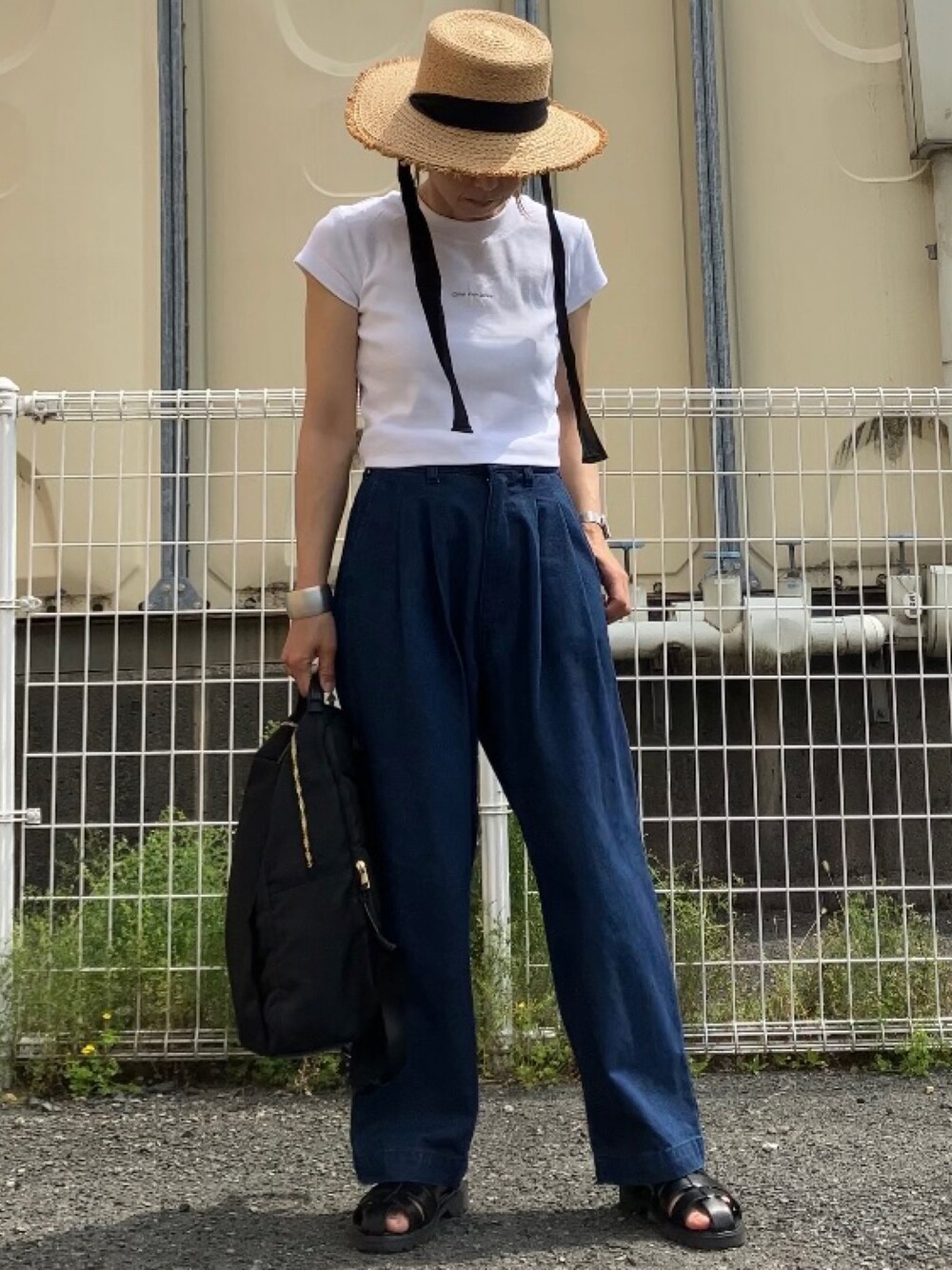 ホワイト系のTシャツ/カットソー、ブルー系のデニムパンツ、ブラック系のサンダルを着用したレディースの春コーディネートの1枚目の写真