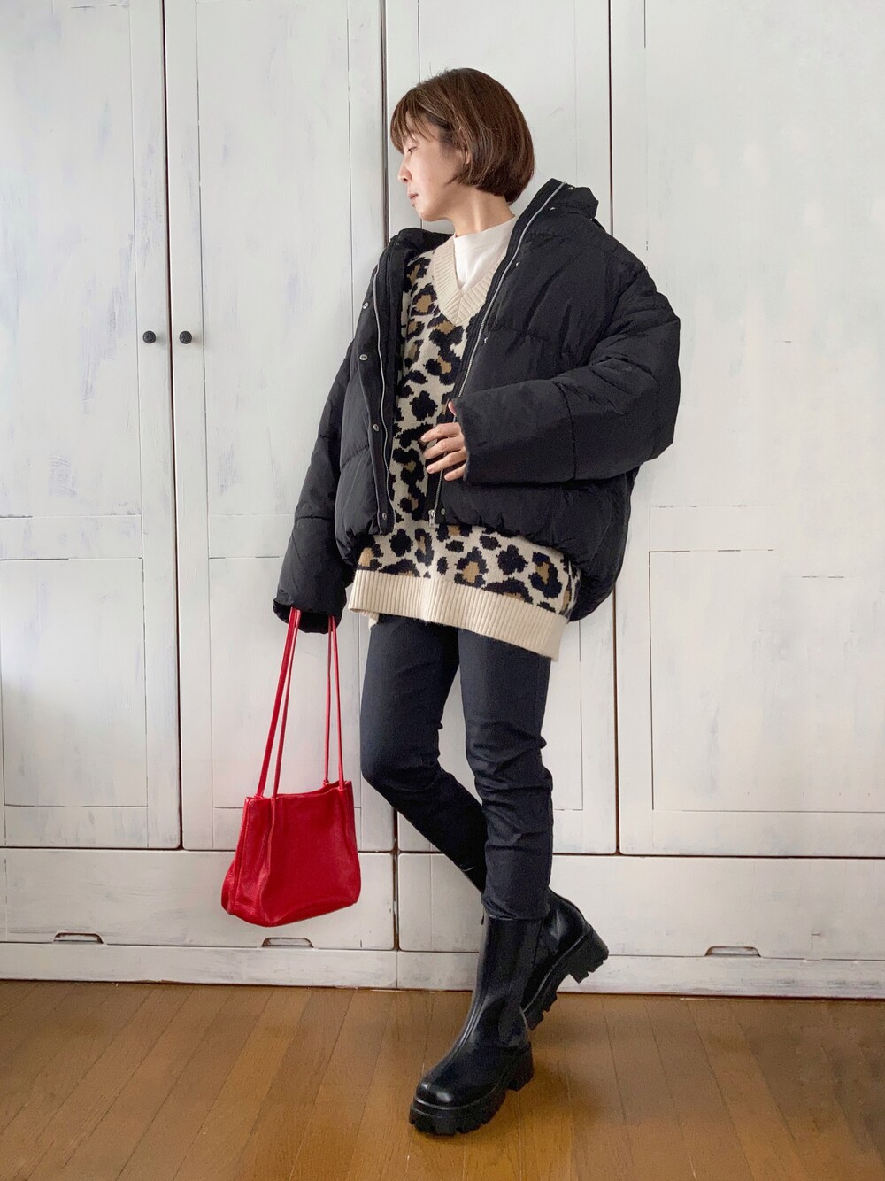 ブラック系のダウンジャケット/コート、ベージュ系のニット/セーター、ブラック系のデニムパンツを着用したレディースの秋コーディネートの1枚目の写真