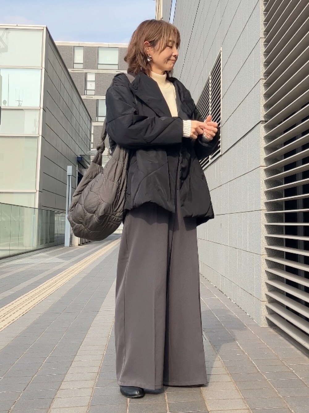 ブラック系のダウンジャケット/コート、ホワイト系のワンピース、グレー系のその他パンツを着用したレディースの冬コーディネートの1枚目の写真