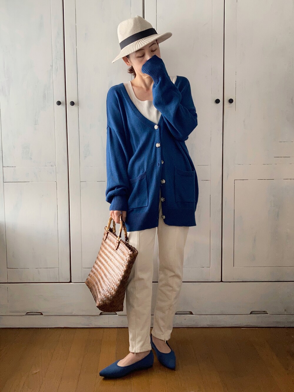 ブルー系のカーディガン/ボレロ、ホワイト系のスウェットパンツ、ブラウン系のかごバッグを着用したレディースの春コーディネートの1枚目の写真