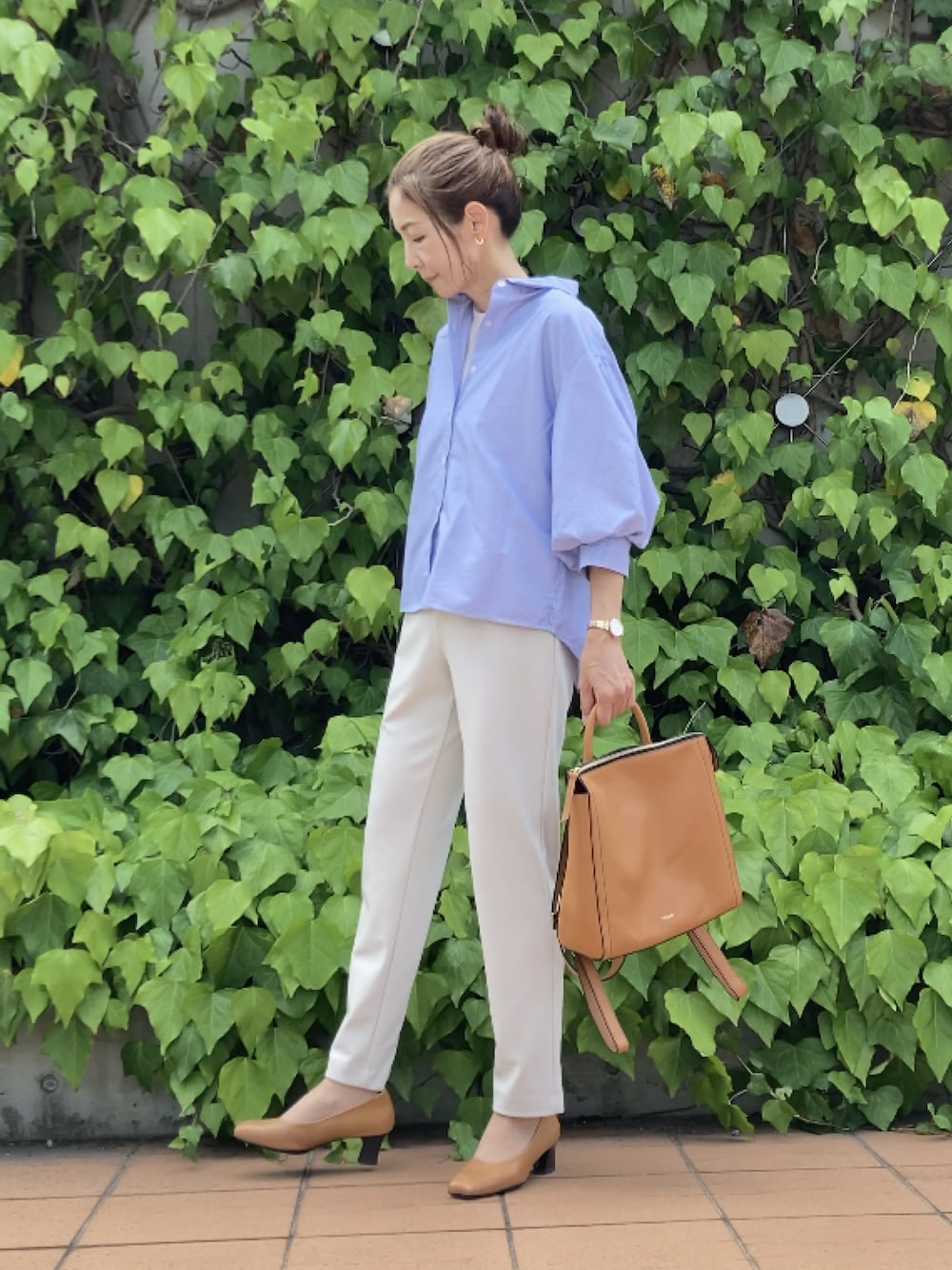 イエロー系のバックパック/リュック、ホワイト系のパンツ、ブルー系のその他トップスを着用したレディースの秋コーディネートの1枚目の写真