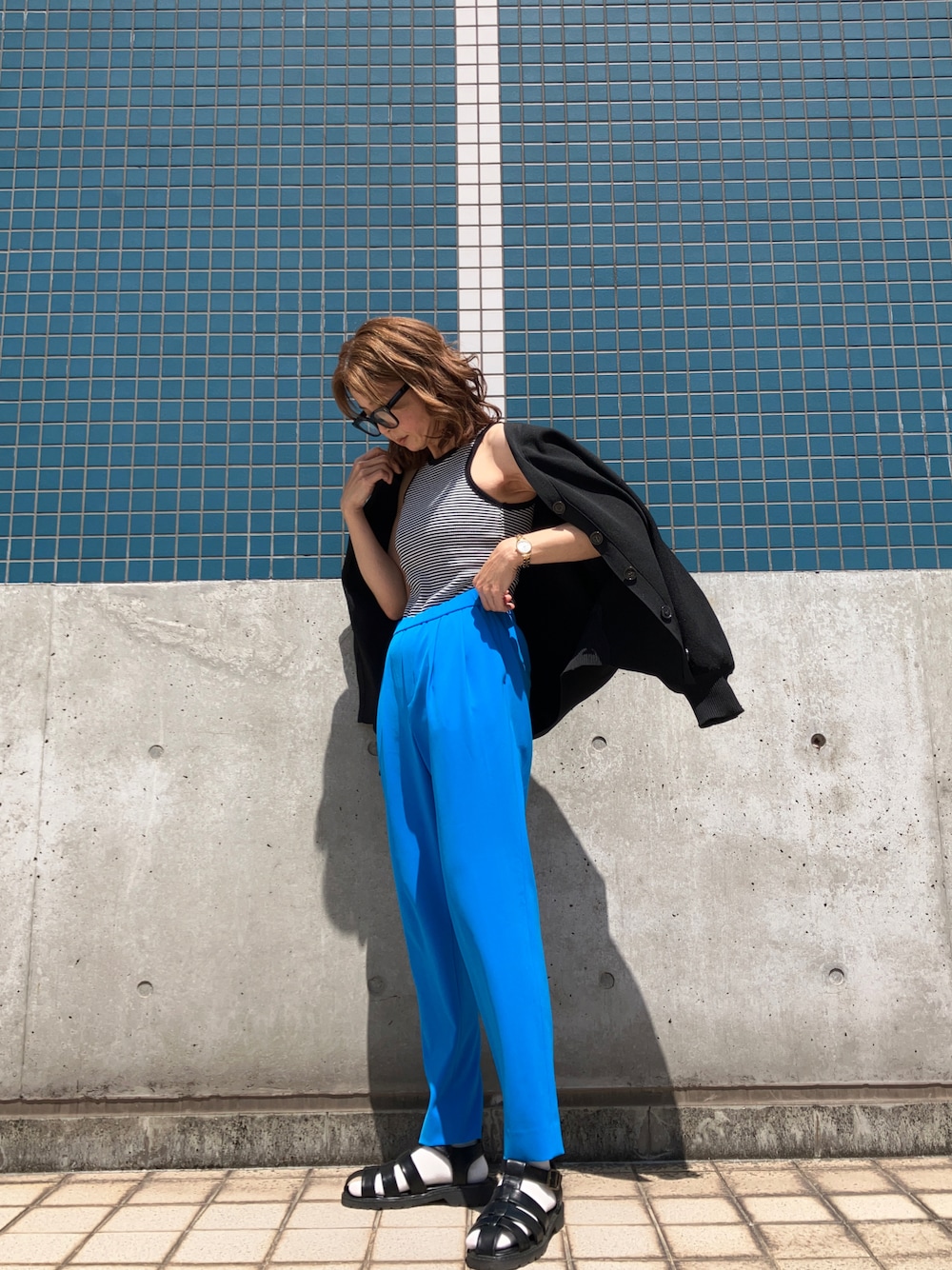 ブラック系のタンクトップ、ブルー系のその他パンツ、ブラック系のサンダルを着用したレディースの春コーディネートの1枚目の写真