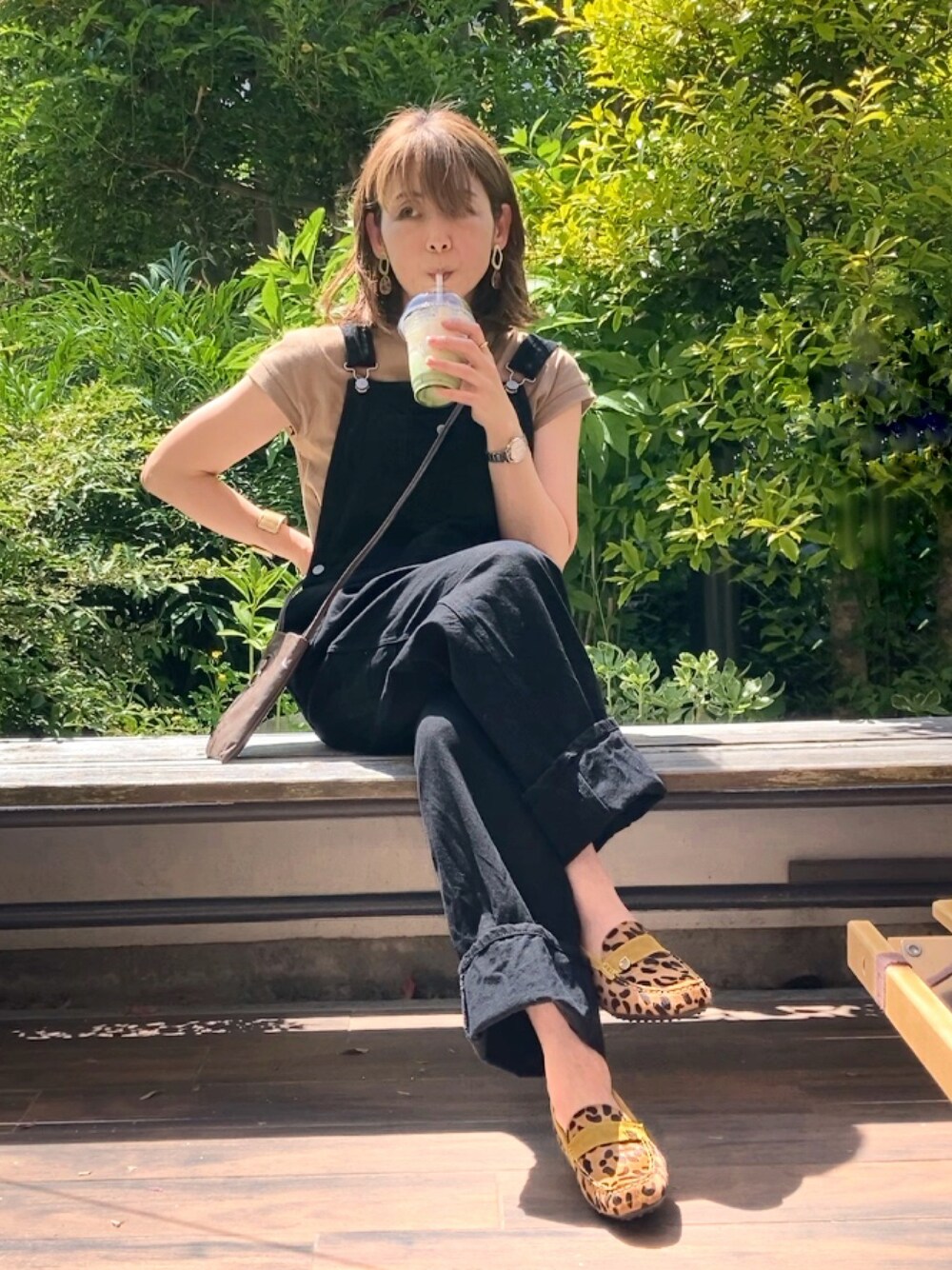 ベージュ系のローファー、ブラック系のサロペット/オーバーオール、ベージュ系のTシャツ/カットソーを着用したレディースの春コーディネートの1枚目の写真