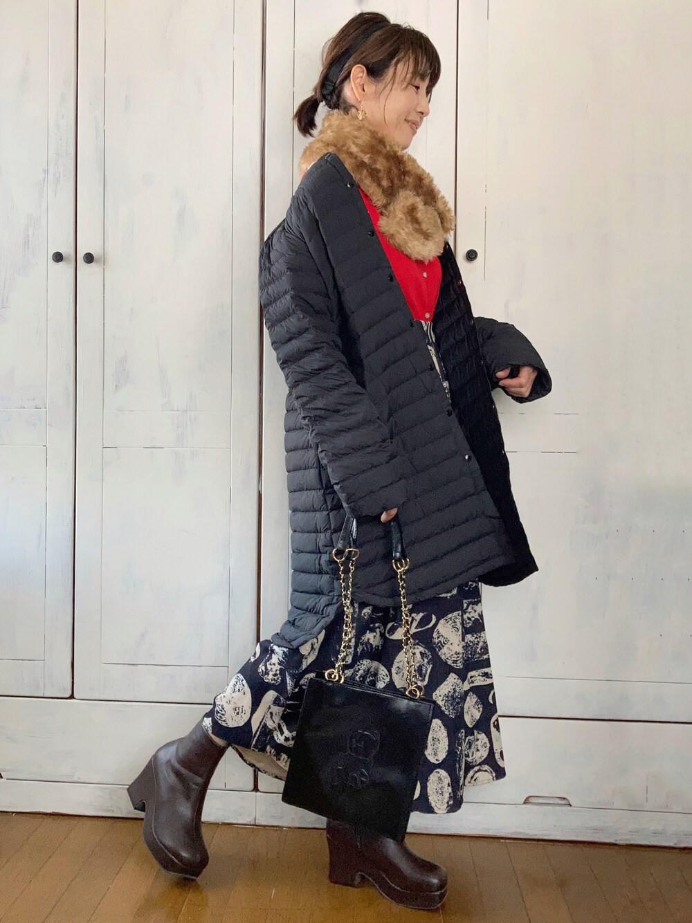 ブラック系のダウンジャケット/コート、ブラック系のスカート、ブラウン系のブーツを着用したレディースの冬コーディネートの1枚目の写真