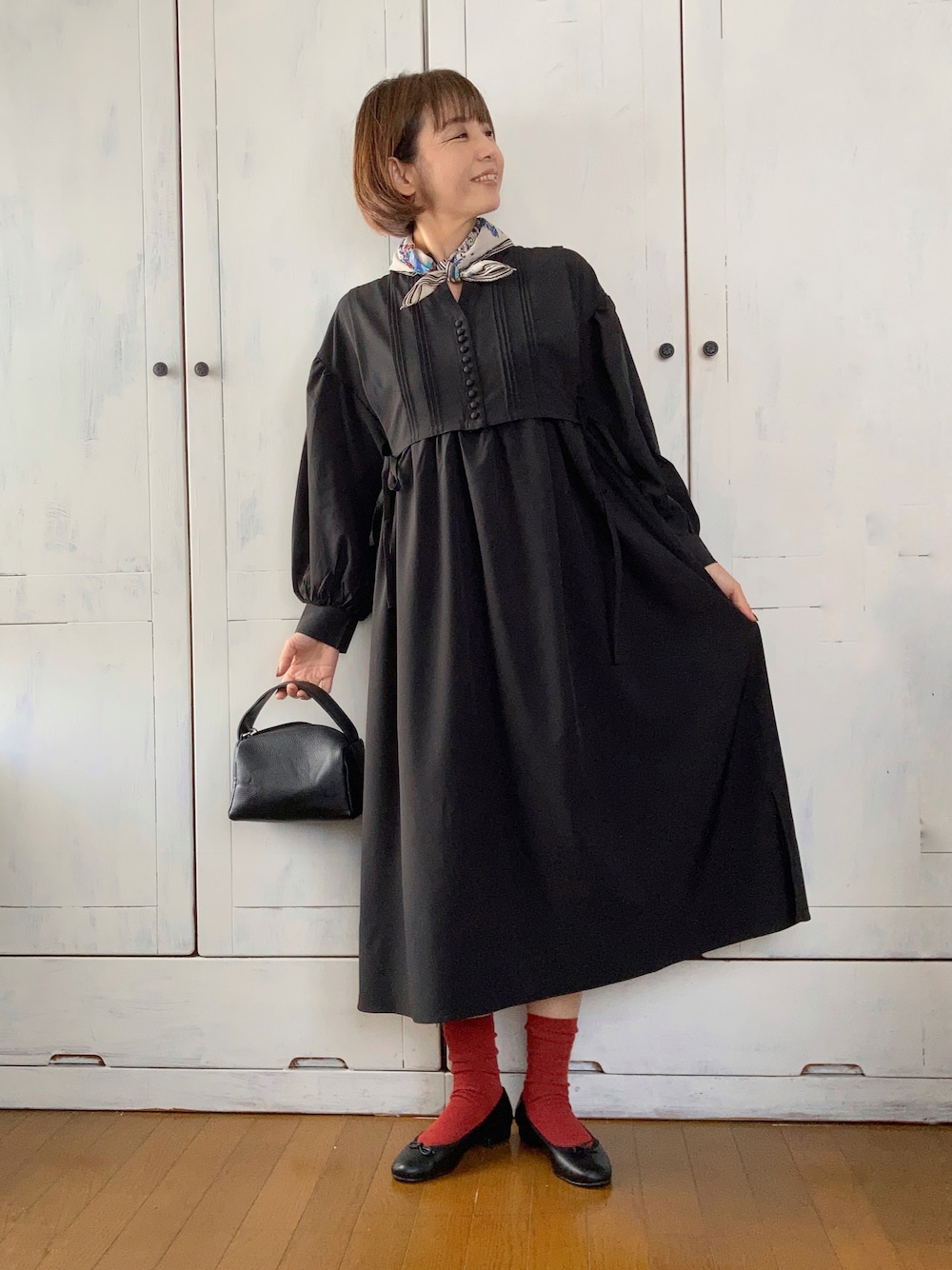 ブラック系のワンピース、ブラック系のハンドバッグ、ブラック系のバレエシューズを着用したレディースの秋コーディネートの1枚目の写真