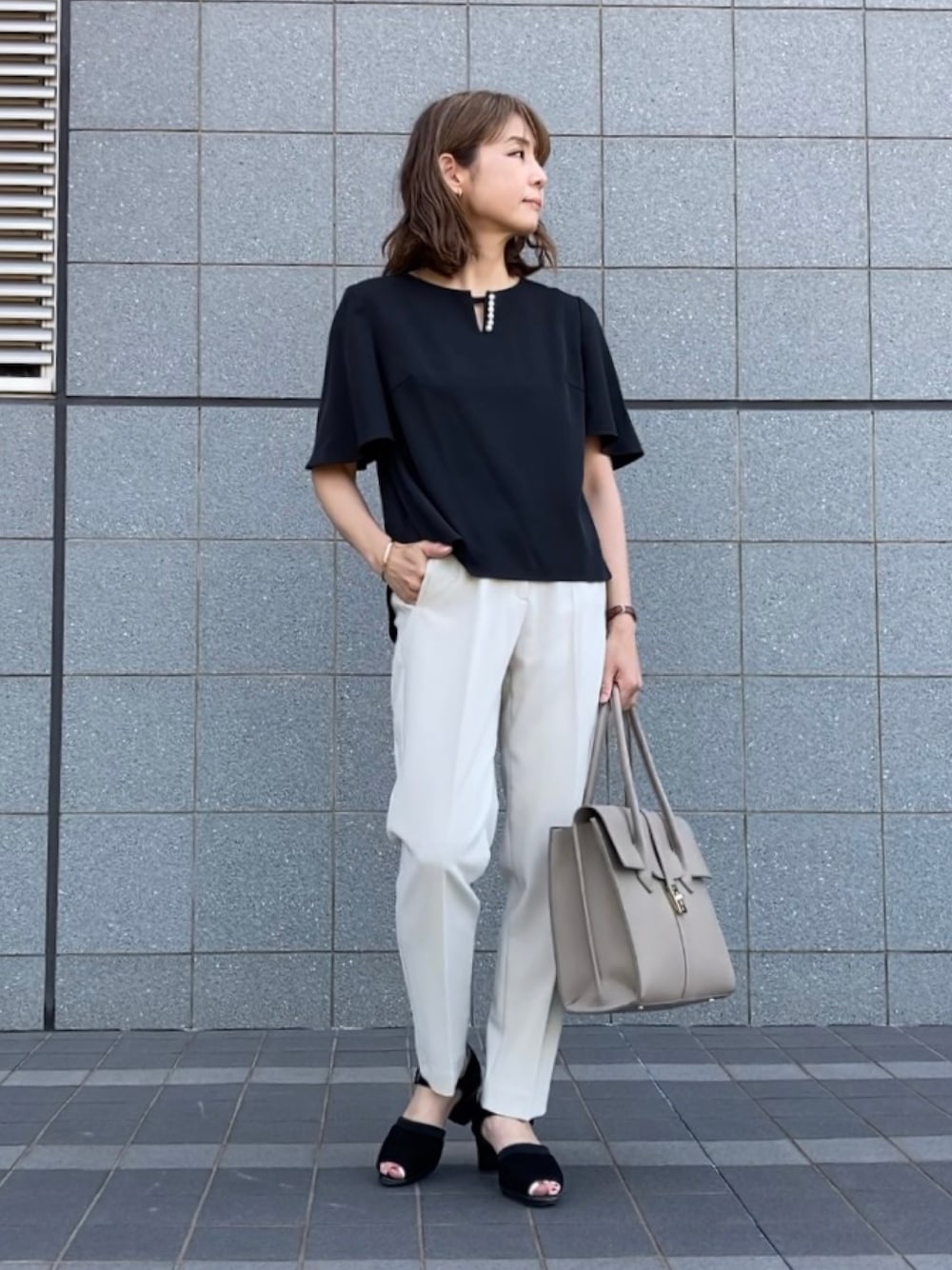 ブラック系のシャツ/ブラウス、ホワイト系のパンツ、ブラック系のサンダルを着用したレディースの春コーディネートの1枚目の写真