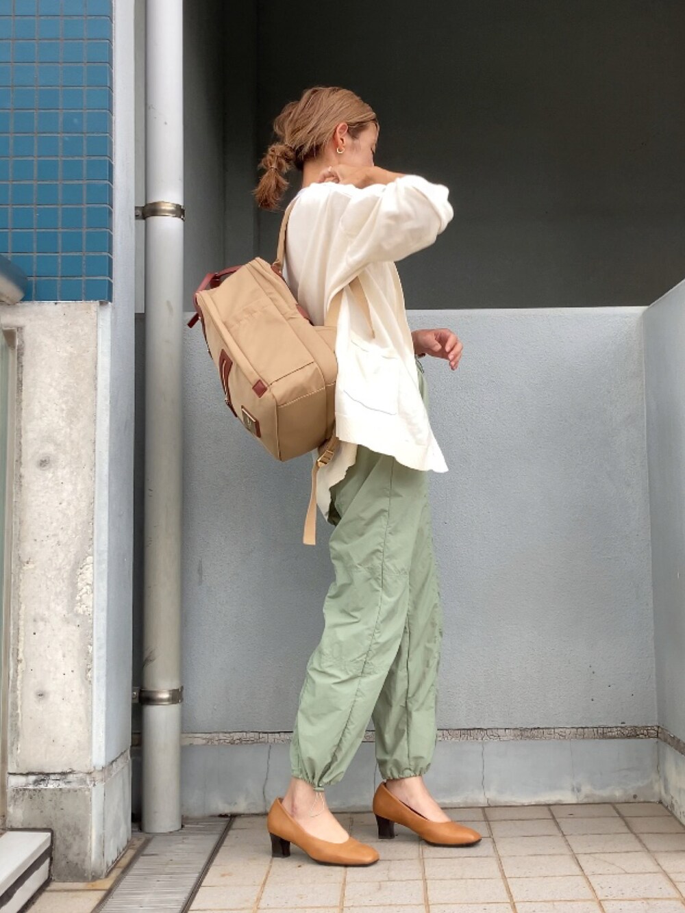 グリーン系のその他パンツ、ベージュ系のパンプス、ベージュ系のバックパック/リュックを着用したレディースの秋コーディネートの1枚目の写真